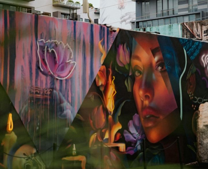 Mural colorido en una pared con edificios de fondo