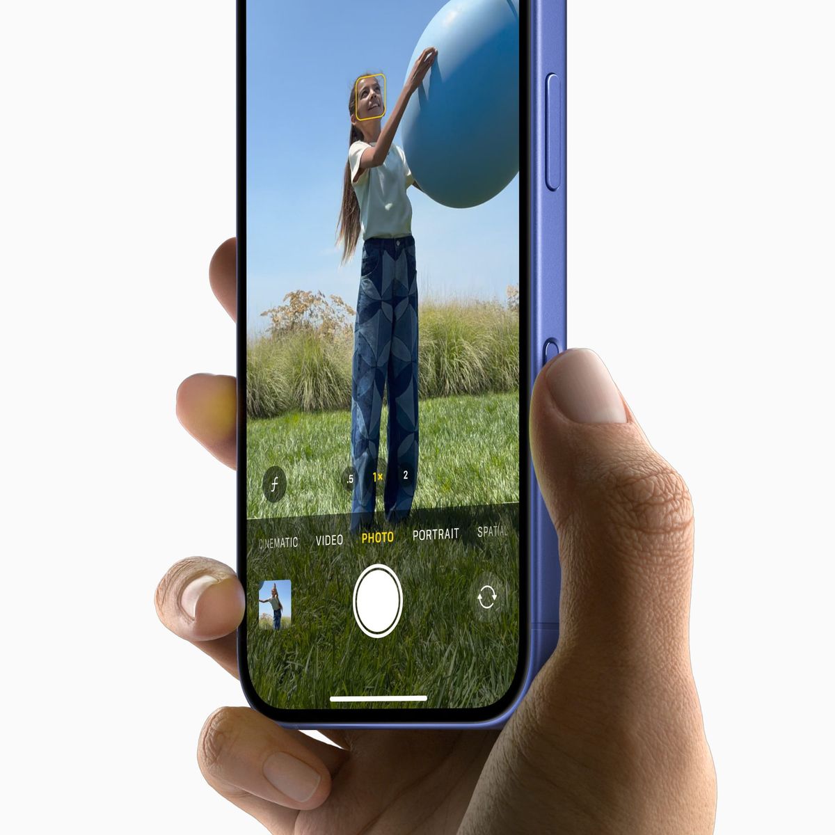 A picture of a person holding an iPhone 16, showcasing the Camera Control