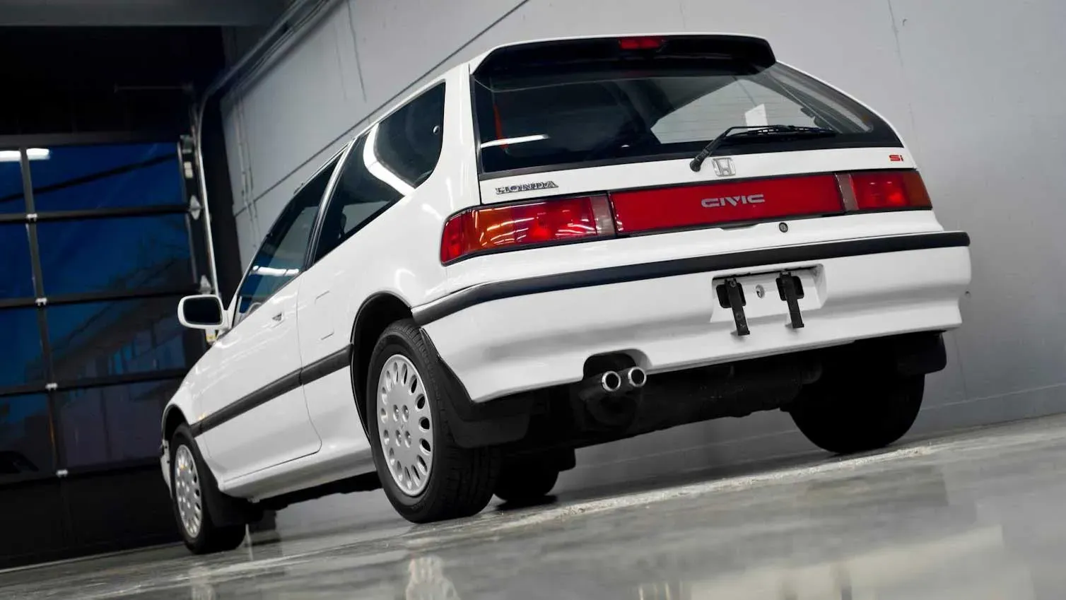 Vista trasera de un Honda Civic Si hatchback EF blanco, destacando su icónico diseño de los 80.
