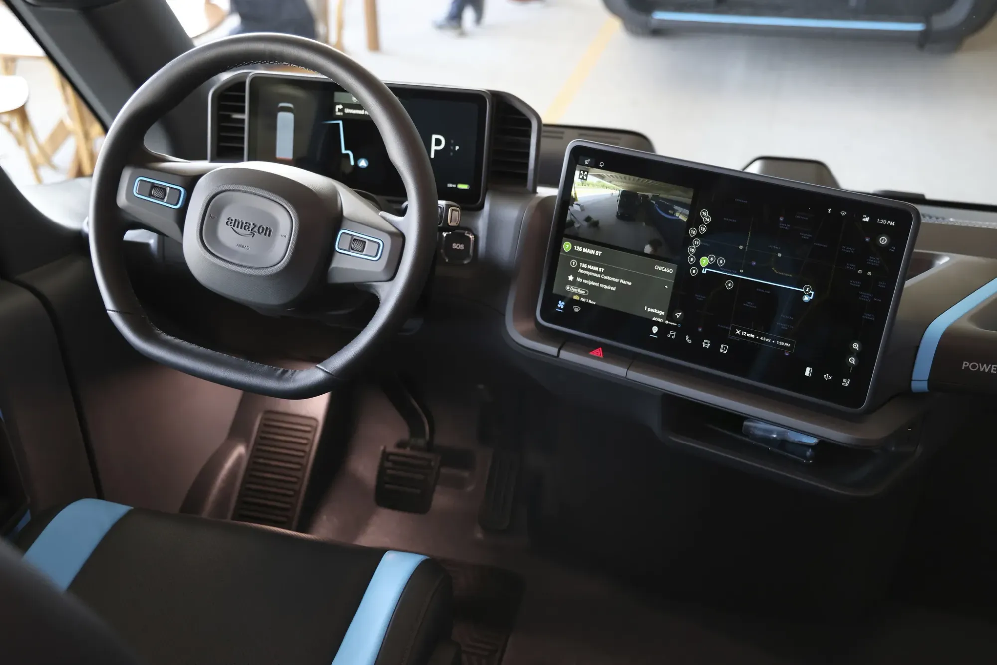 Vista del interior funcional del Rivian EDV 700, mostrando el asiento único y la consola central
