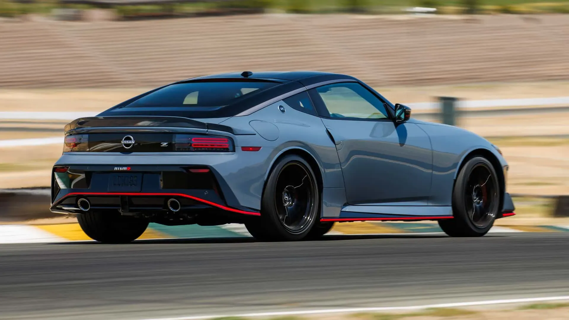 Vista trasera del Nissan Z Nismo 2025 en color celeste, mostrando alerón y salida de escape