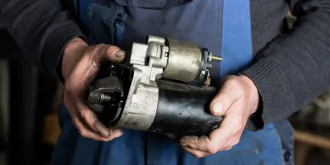 Persona sosteniendo arranque desmontado de auto