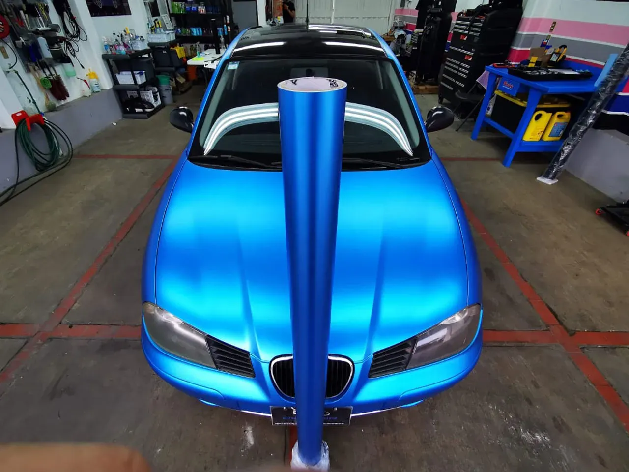 Rollo de vinil azul frente auto en taller mecanice