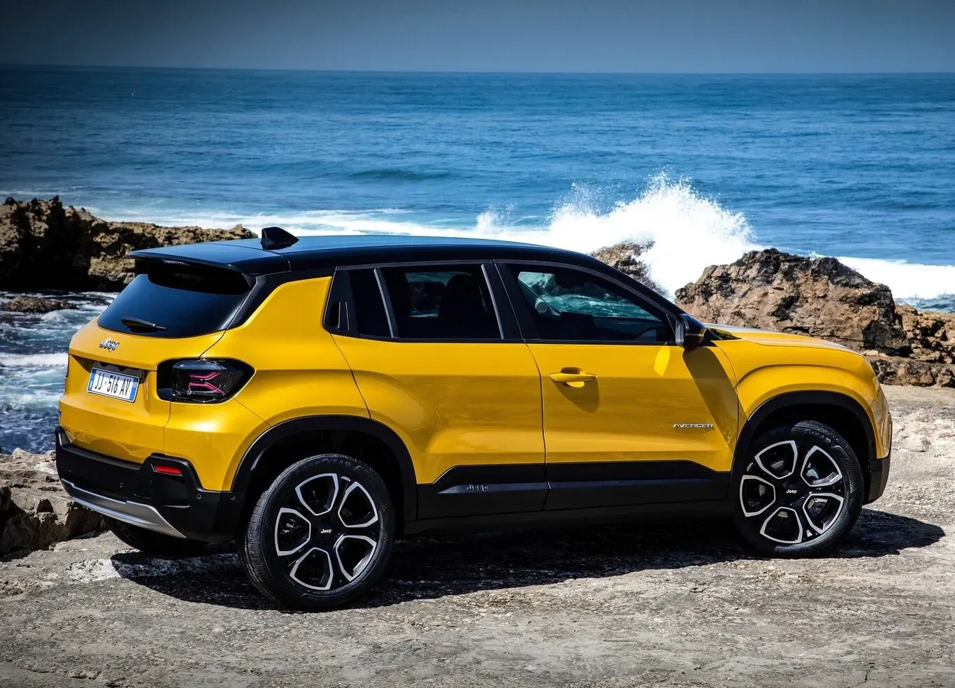Vista lateral de un Jeep Avenger amarillo en un camino de tierra
