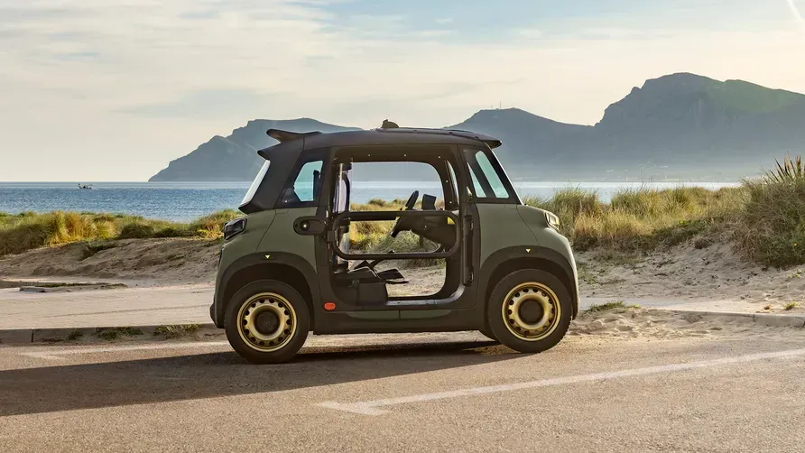 Vista lateral del Citroën My Ami Buggy en color verde, mostrando su diseño sin puertas y neumáticos de tacos