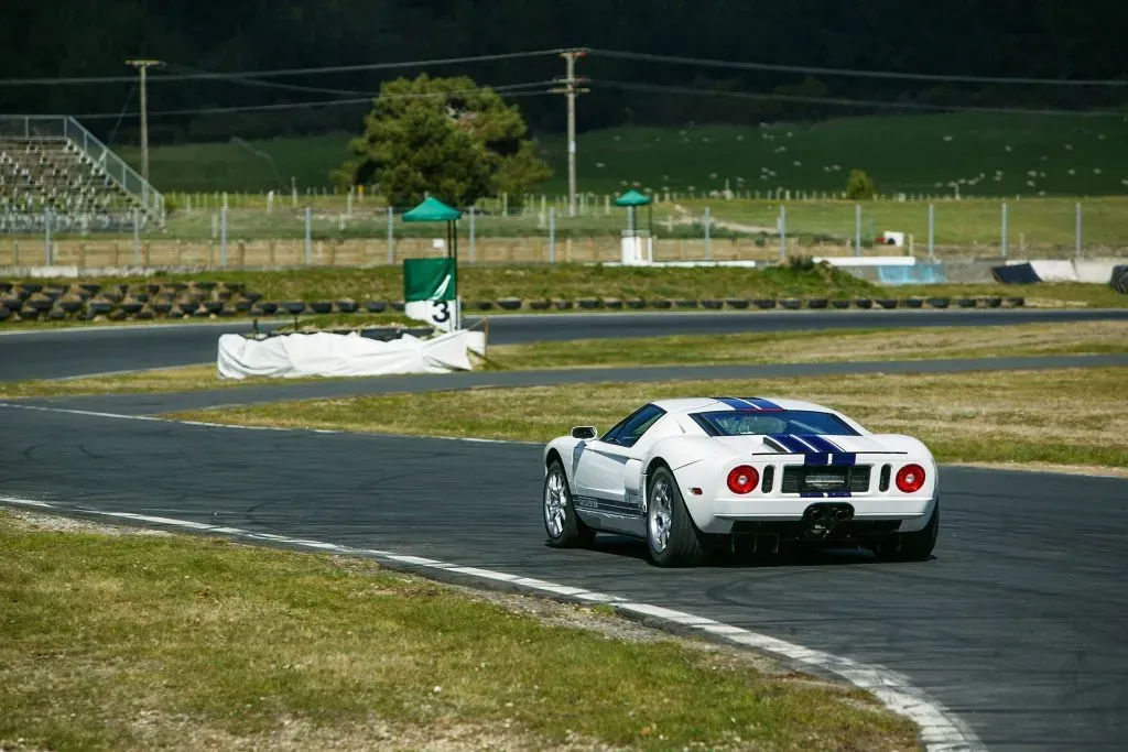 Parte Trasera de un Ford GT 2005 color blanco en un circuito de carreras, demostrando su rendimiento.