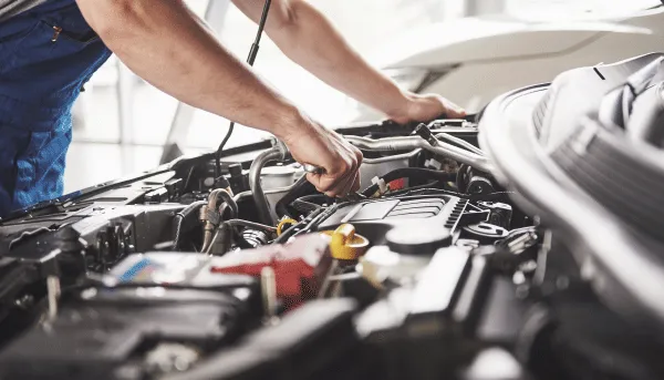 Persona revisando parte mecánica de un auto