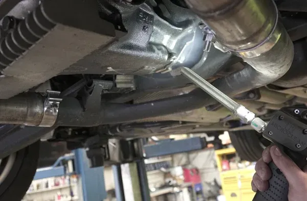 Técnico aplicando limpieza con hielo seco en el motor de un vehículo
