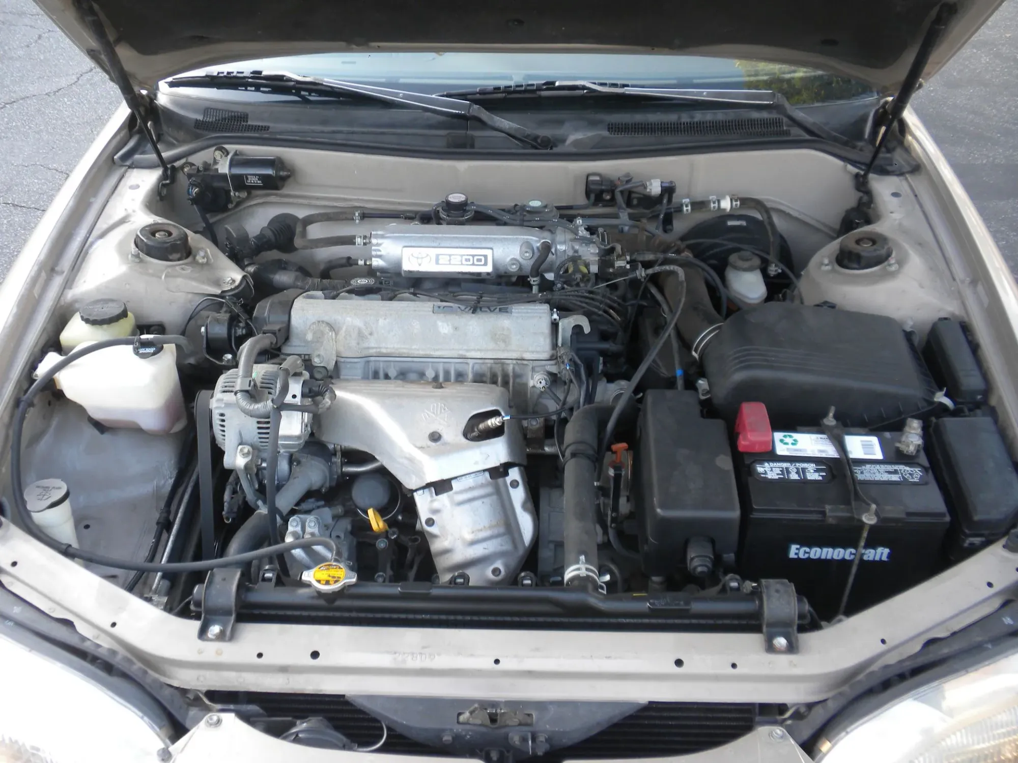 Capo abierto del Toyota Camry 1996 mostrando parte mecánica y motor