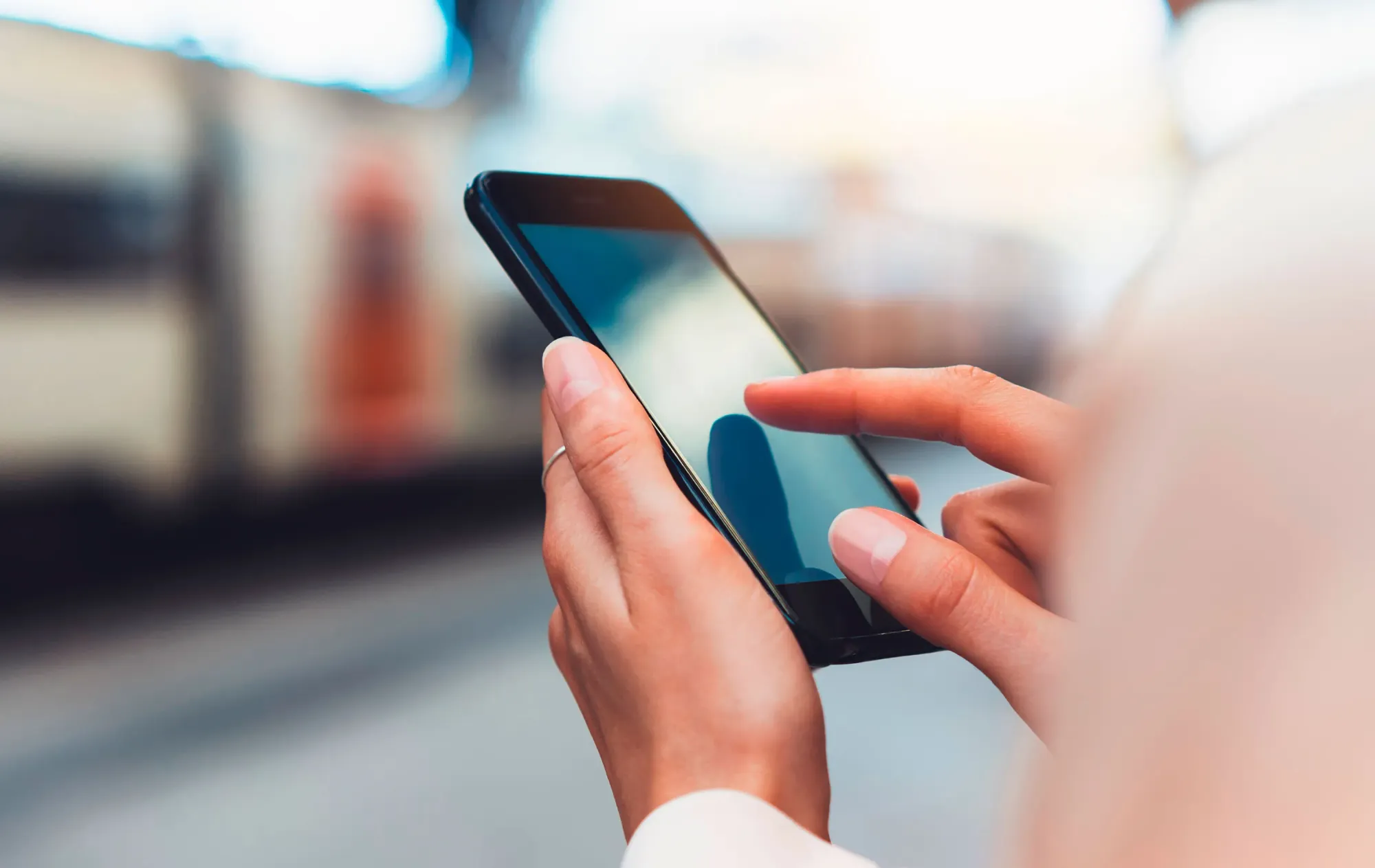 Manos sosteniendo un teléfono y tocando la pantalla
