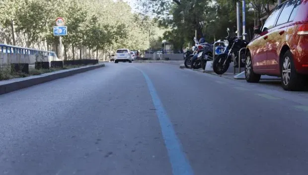 Líneas azules marcando el trazado de fibra óptica en el arcén de una carretera