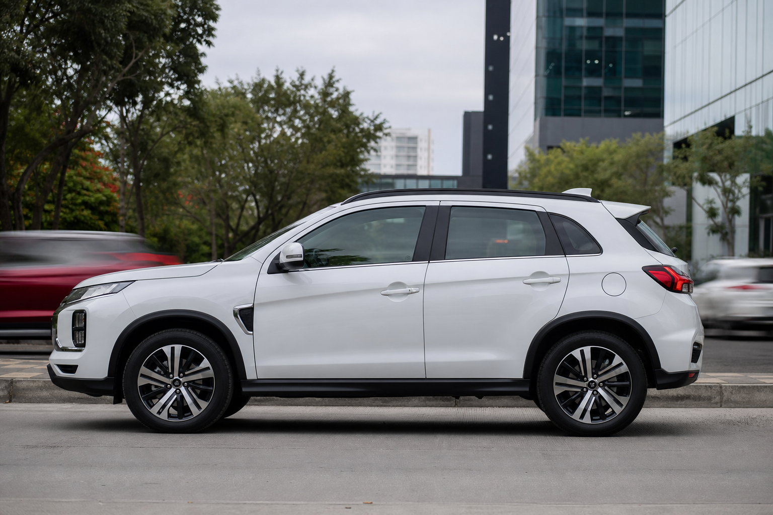 Vista lateral del Mitsubishi Outlander Sport 2026 blanco con rines de 18 pulgadas en calle urbana de Guadalajara