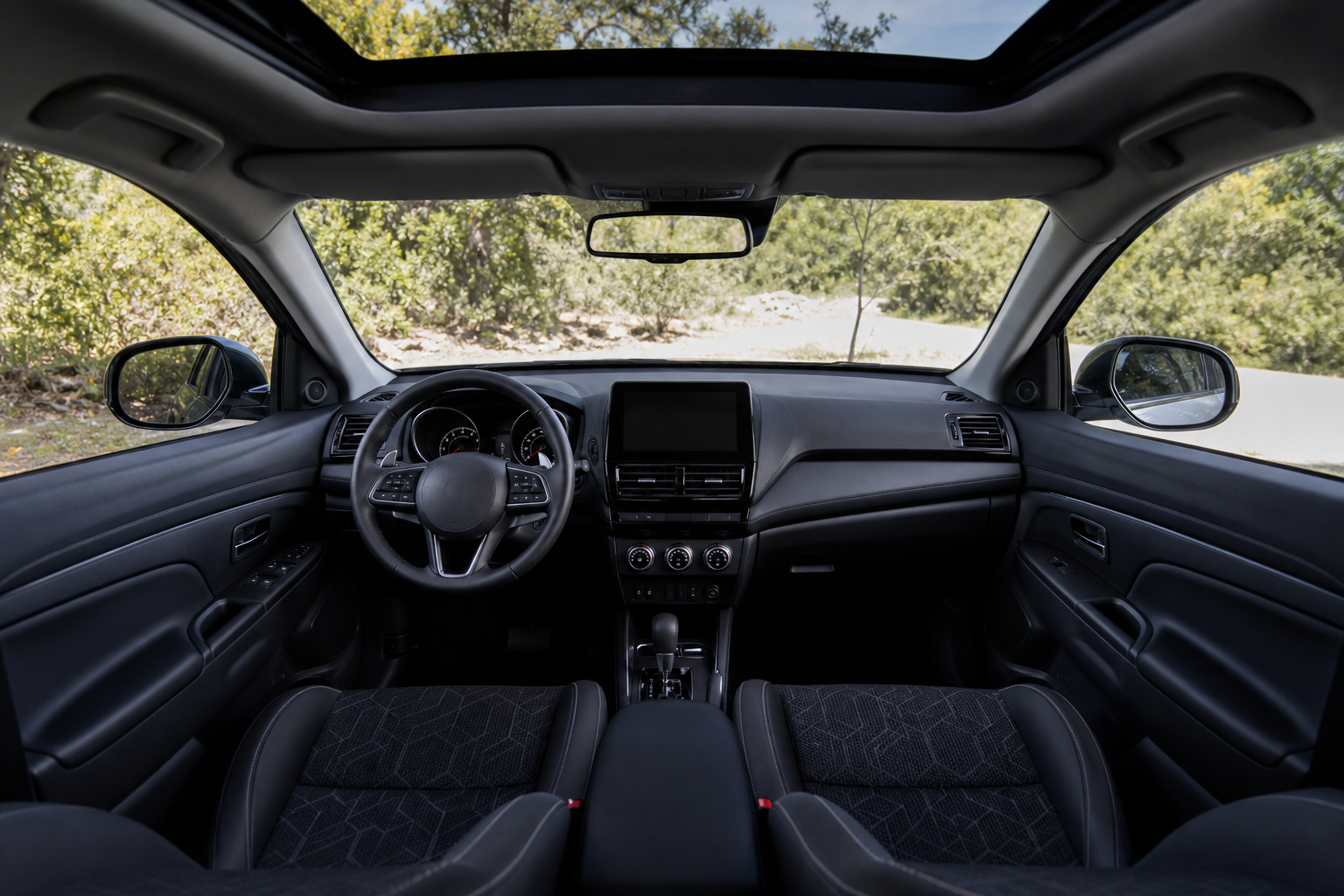 Interior del Mitsubishi Outlander Sport 2026 con tablero, volante y asientos de tela