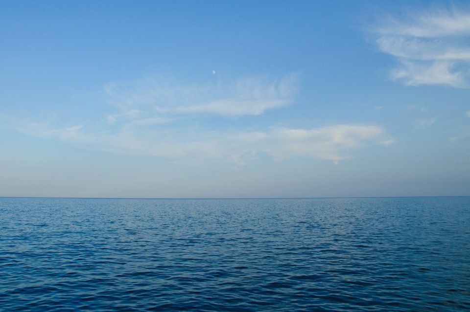 blue body of water under white clouds