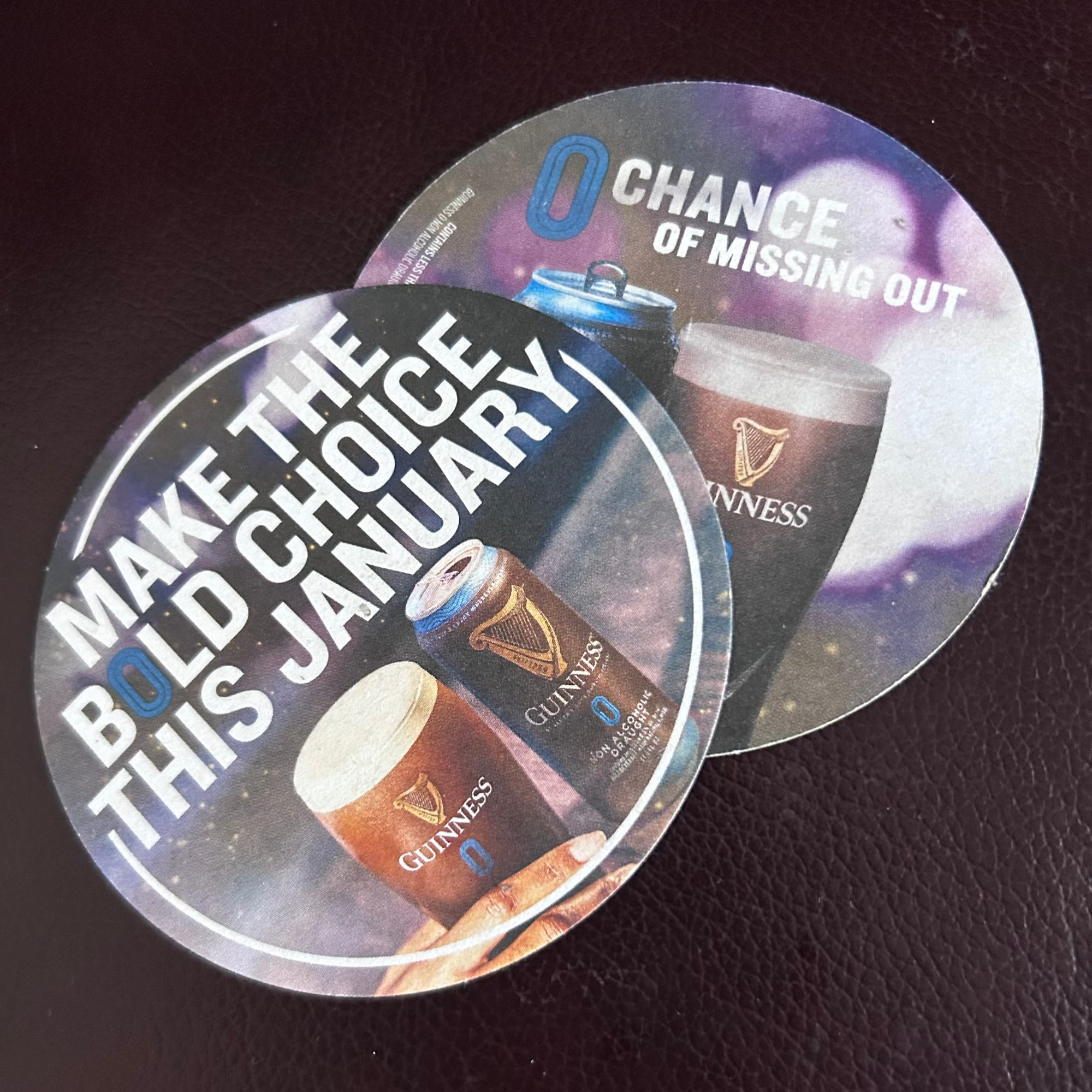 Round beer mats, or coasters, with Guinness 0.0 can and pint and one one side it says "Make the Bold Choice this January" on the other "zero chance of missing out"