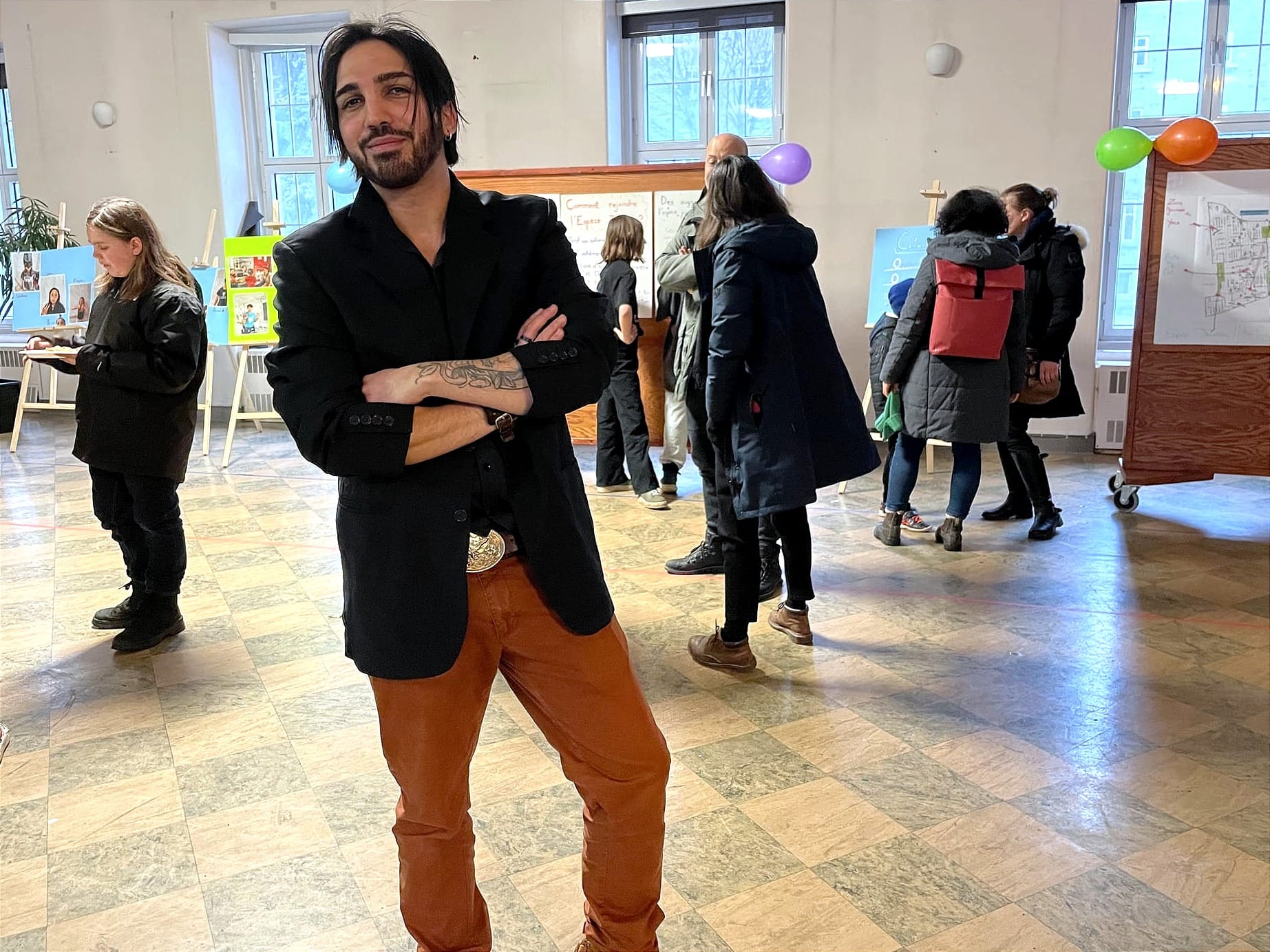 M. Aliskandaria pose dans la salle communautaire, alors qu'on aperçoit d'autres participants de la célébration derrière lui.