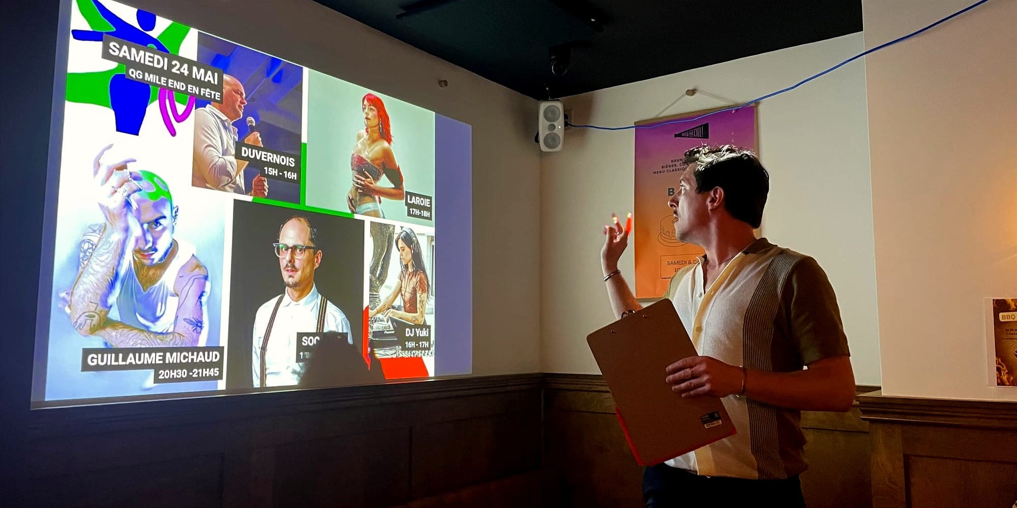 Gabriel Dallaire debout devant une projection d'images des artistes en tête d'affiche. 