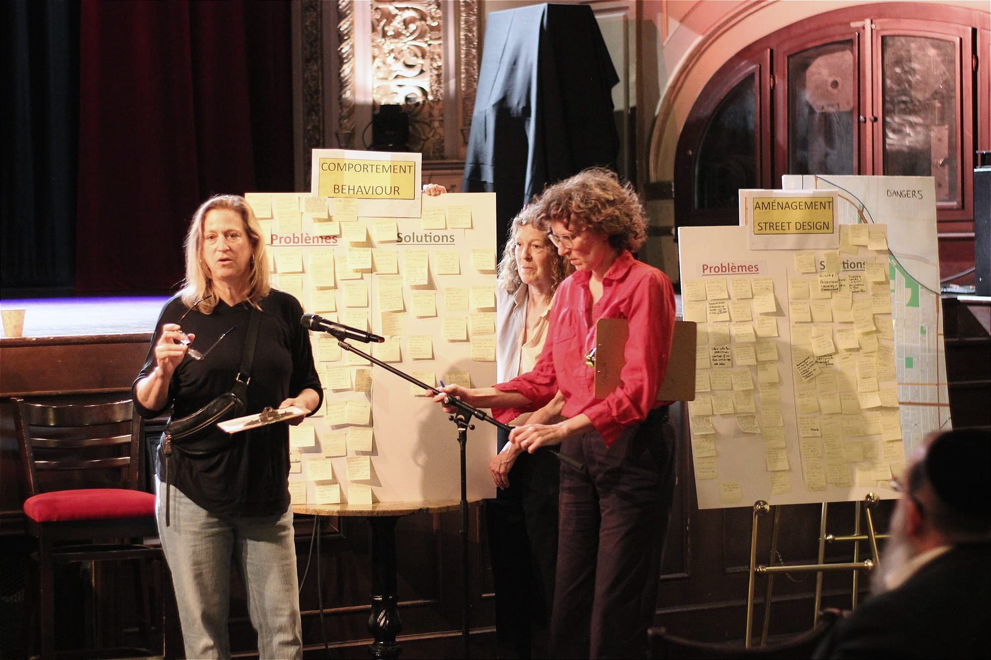 Un femme explique les résultats regroupés sur différents tableaux placés derrière elle.