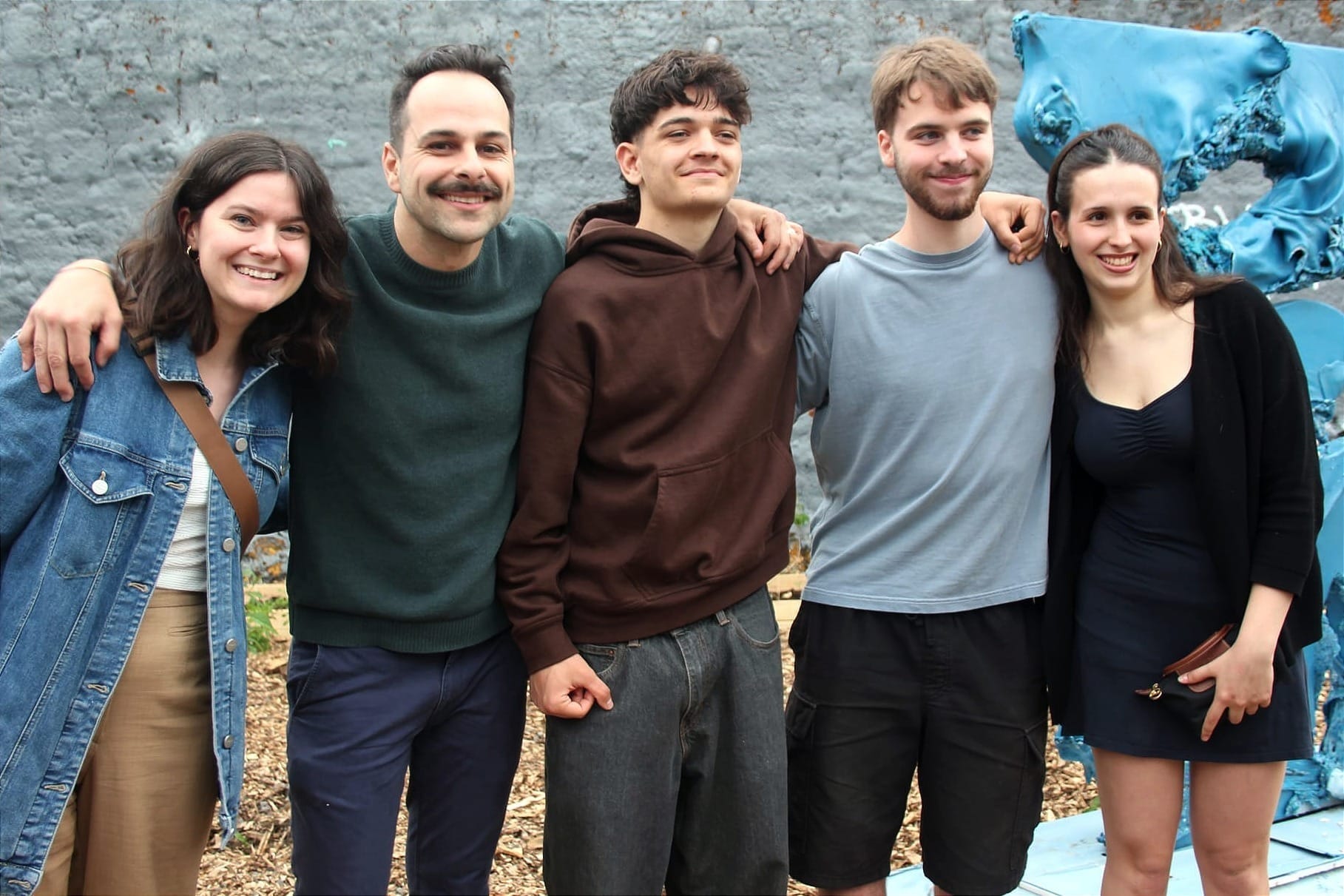 Les cinq posent devant la sculpture du Studio Ascètes.
