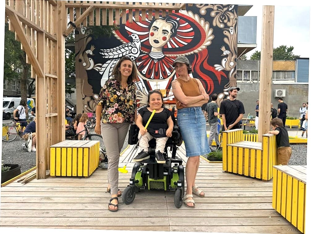 Les trois femmes posent sur une passerelle au milieu de la place publique.