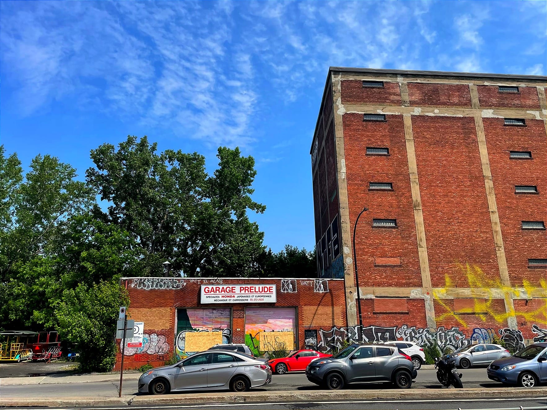 On voit l'édifice avec l'enseigne «Garage Prélude», encore sur son mur, malgré l'apparence d'abandon.