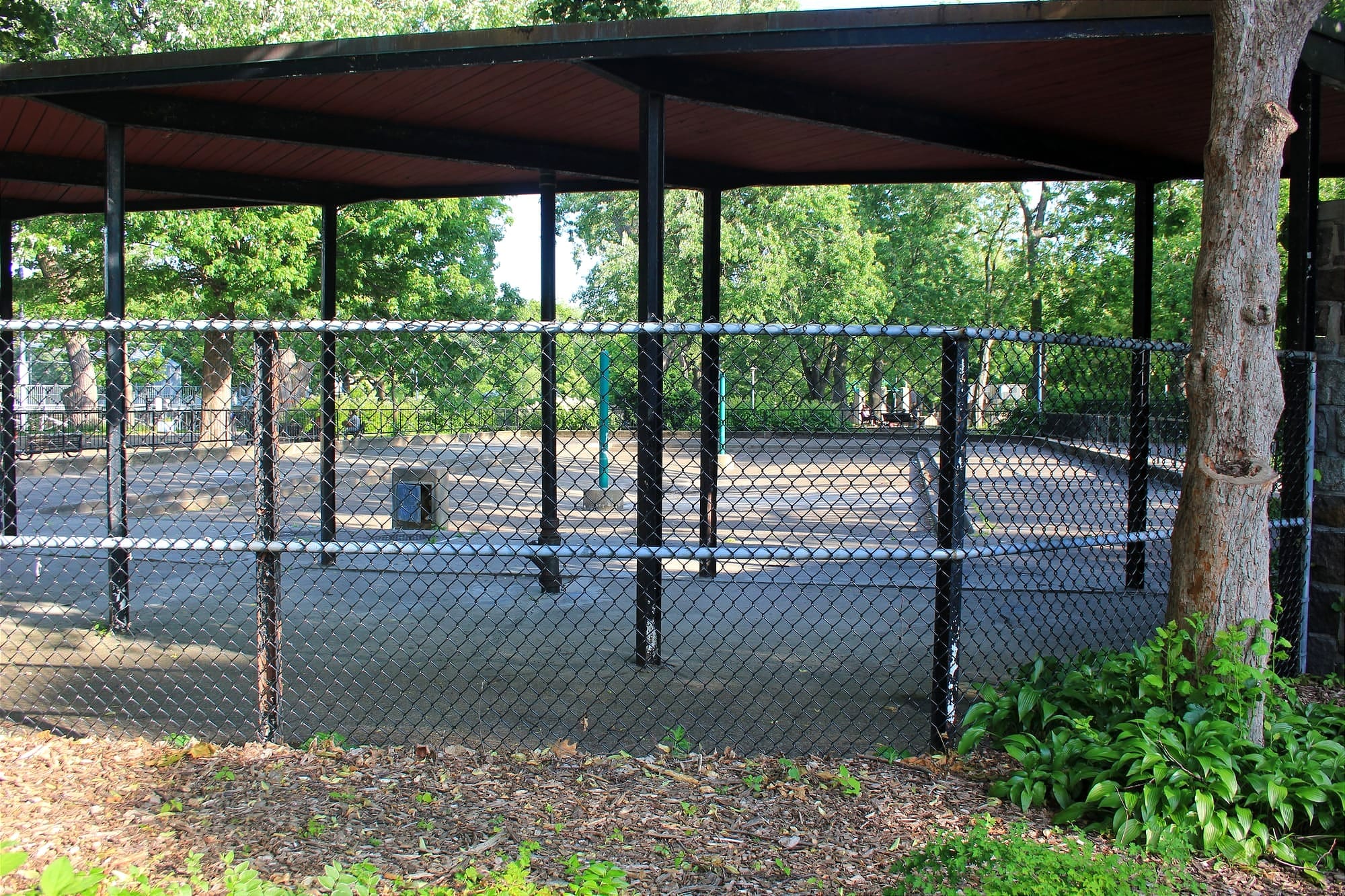 On voit la pataugeoire vide derrière une clôture. 