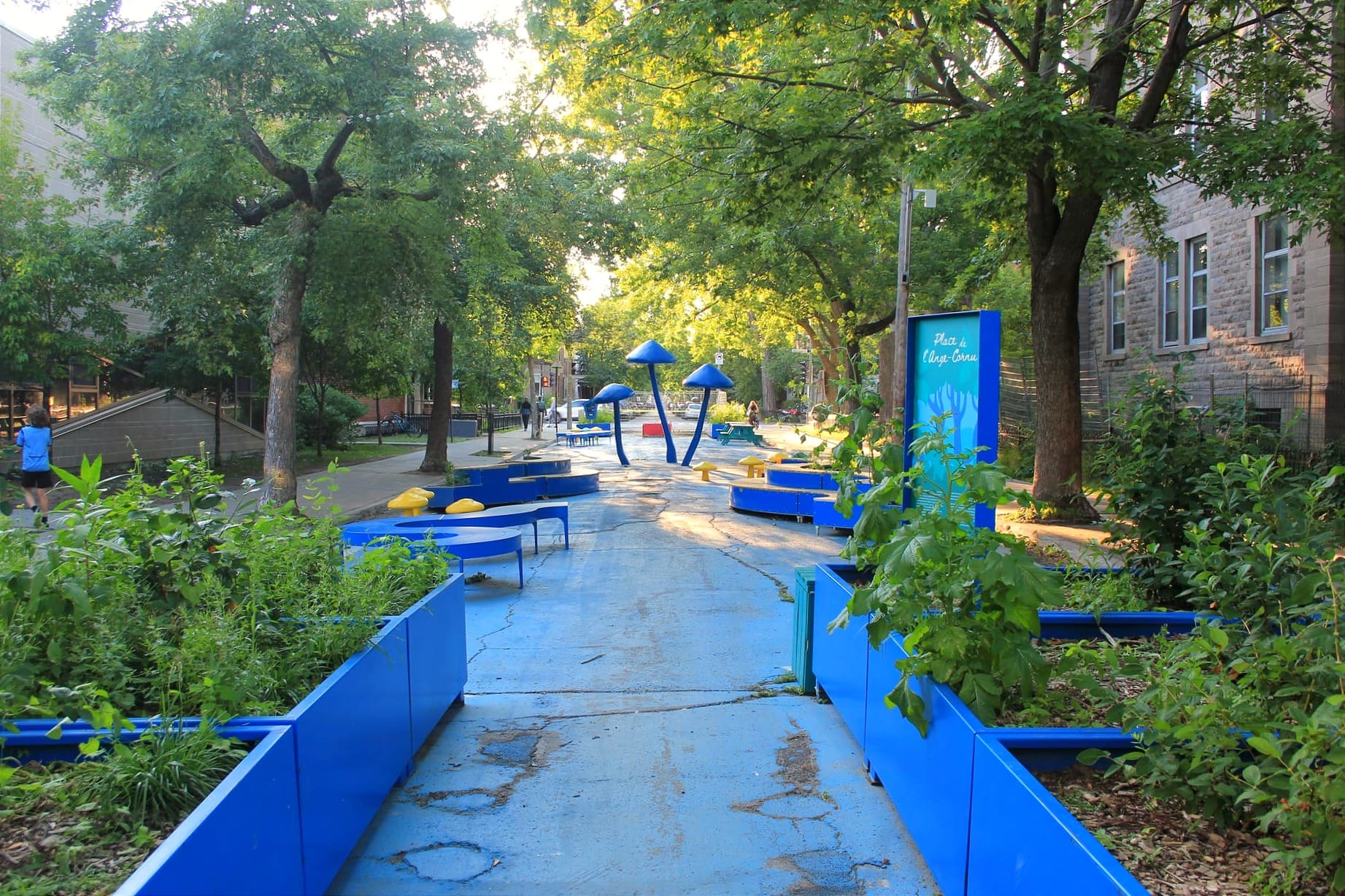 On voit les bacs à fleurs, les bancs courbés et les champignons qui ornementent le décor bleu de la place de l'Ange-Cornu. 