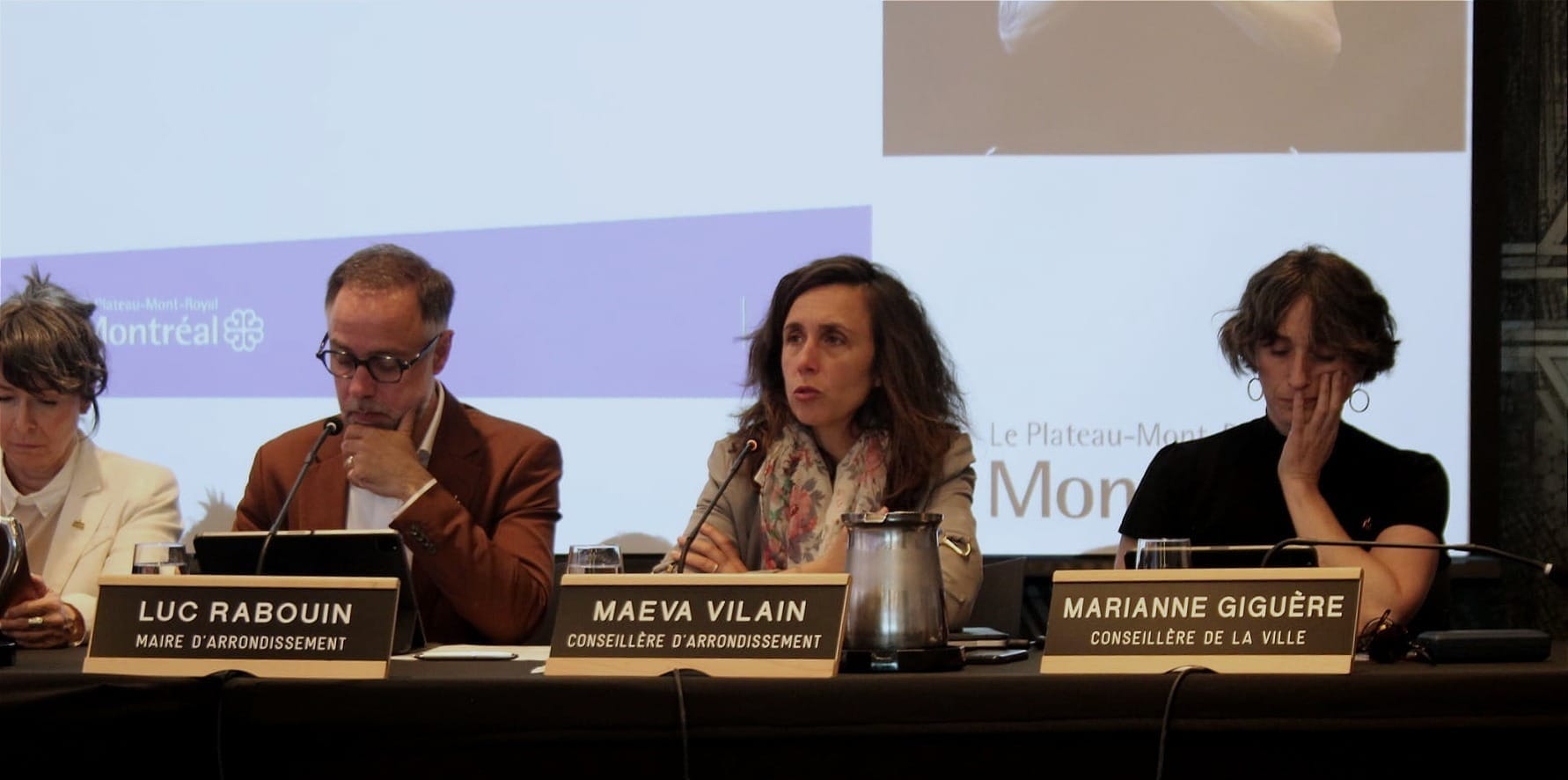 On voit Mme Vilain prendre la parole, à sa gauche, la conseillère Marianne Giguère, à sa droite, le maire Luc Rabouin et la conseillère Marie Plourde.
