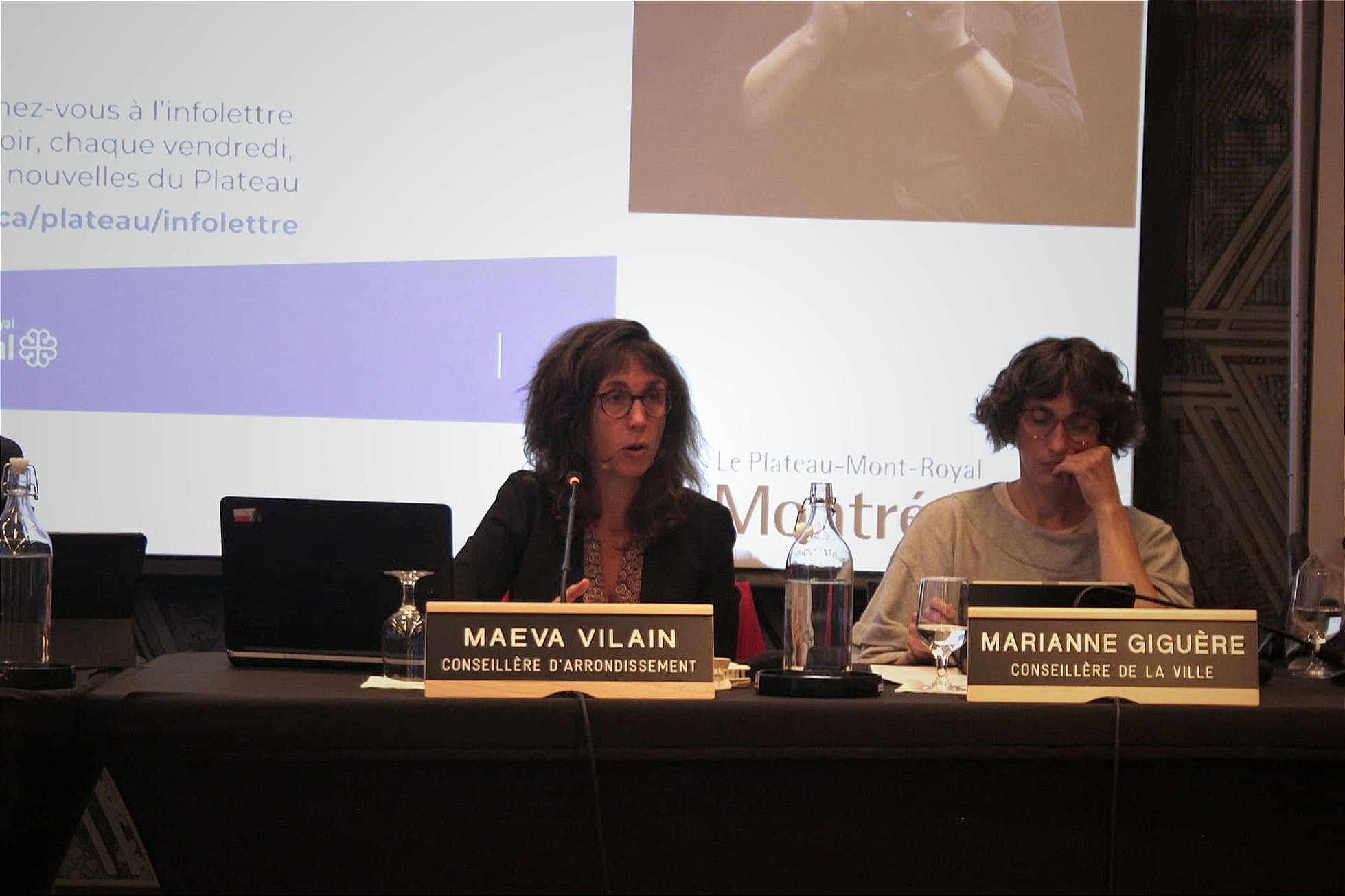 Mme Vilain prend la parole à la table des élus. On voit la conseillère Marianne Giguère à sa gauche.