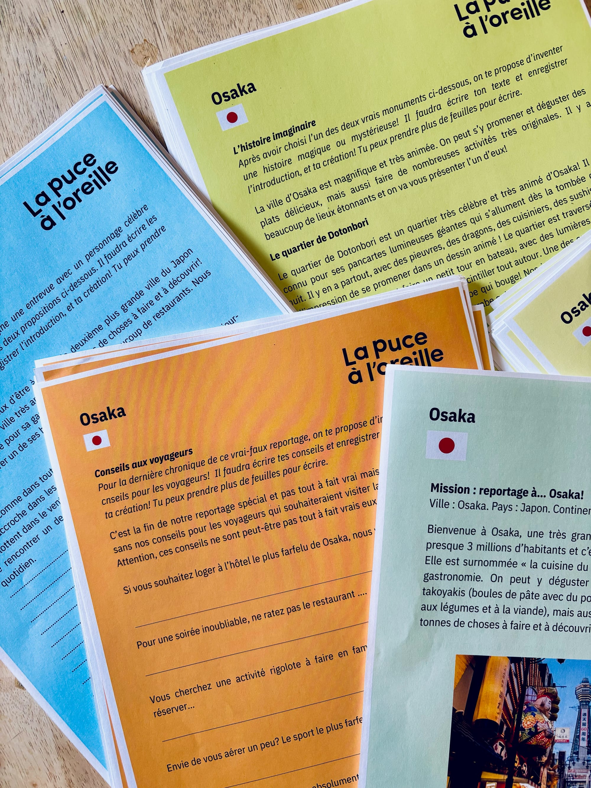 Différentes pages d'une pochette de création sur la ville d'Osaka sont éparpillées sur une surface. 