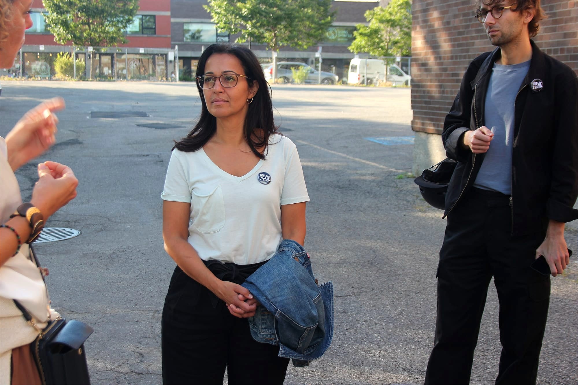 Ruba Ghazal, veste en main, écoute une femme à l'extrémité gauche du cadre, pendant que son attaché politique demeure à l'affut un peu plus loin. 