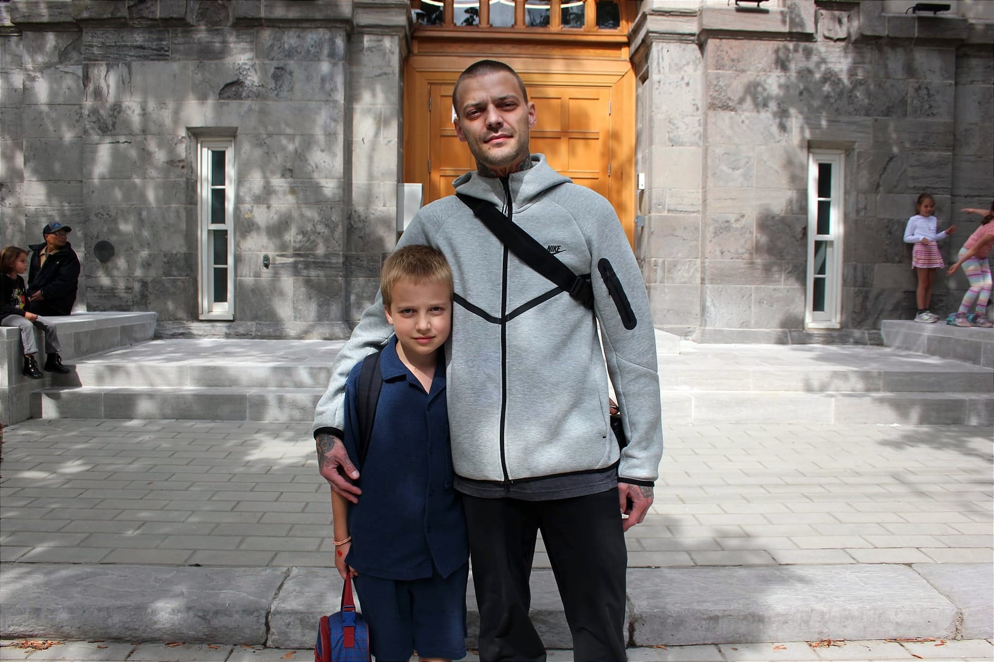Wilder et Guillaume Cheny posent devant une entrée de la nouvelle école FACE. 