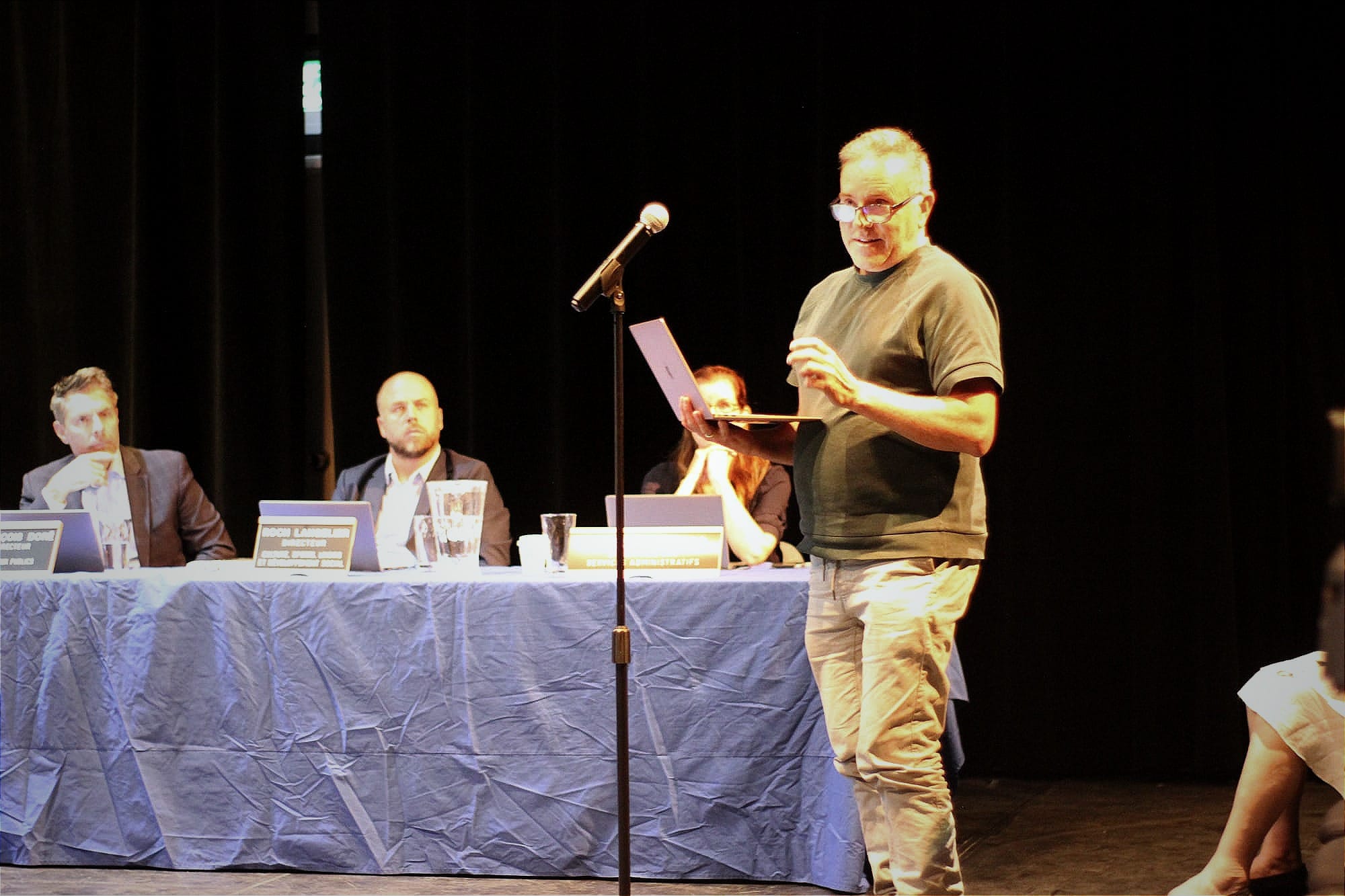 M. Lemieux, debout, ordinateur portable en main, devant le micro, s'adressant aux réprésensants d'arrondissement. 