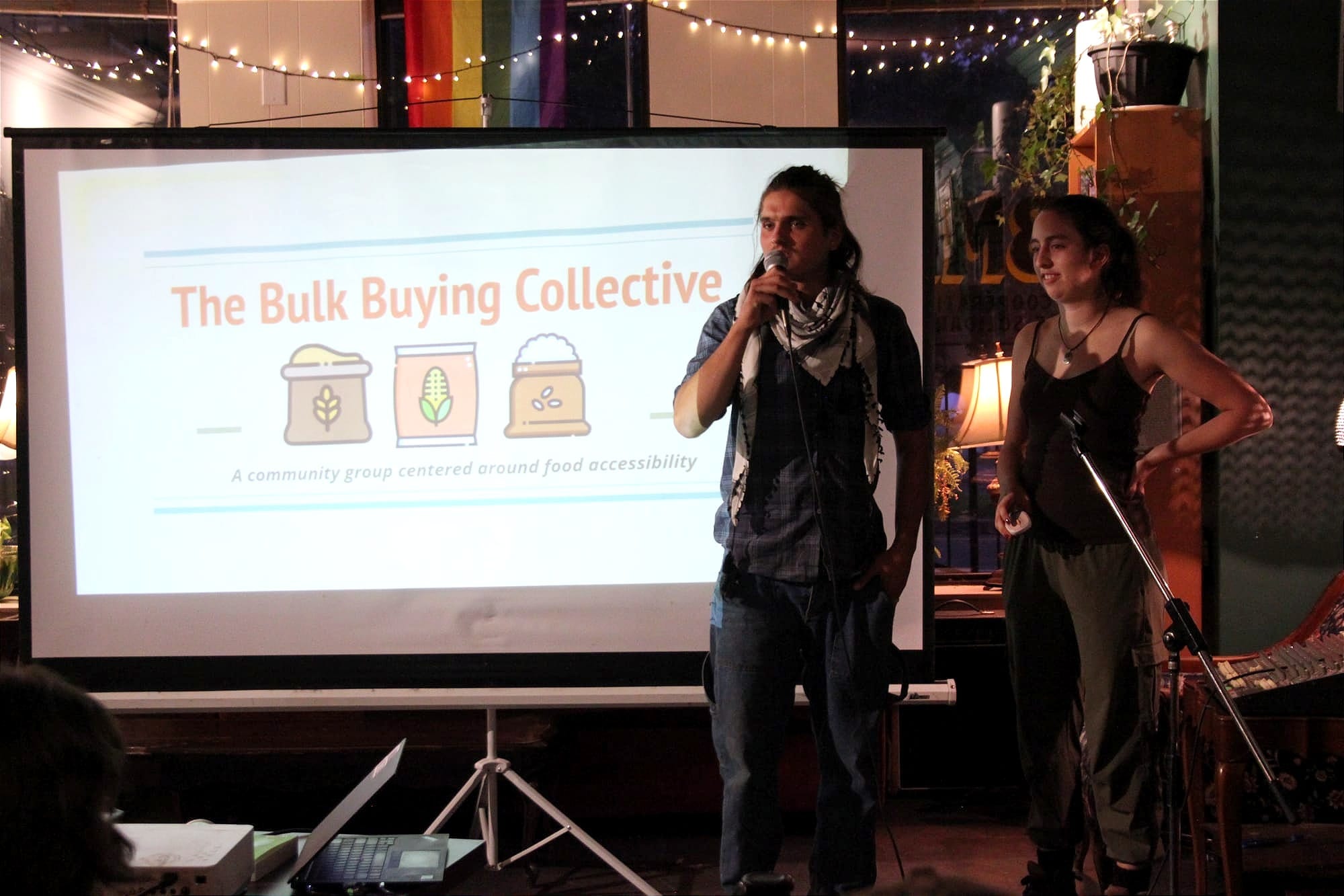 Les deux se tiennent debout devant une projection de leur présentation. 
