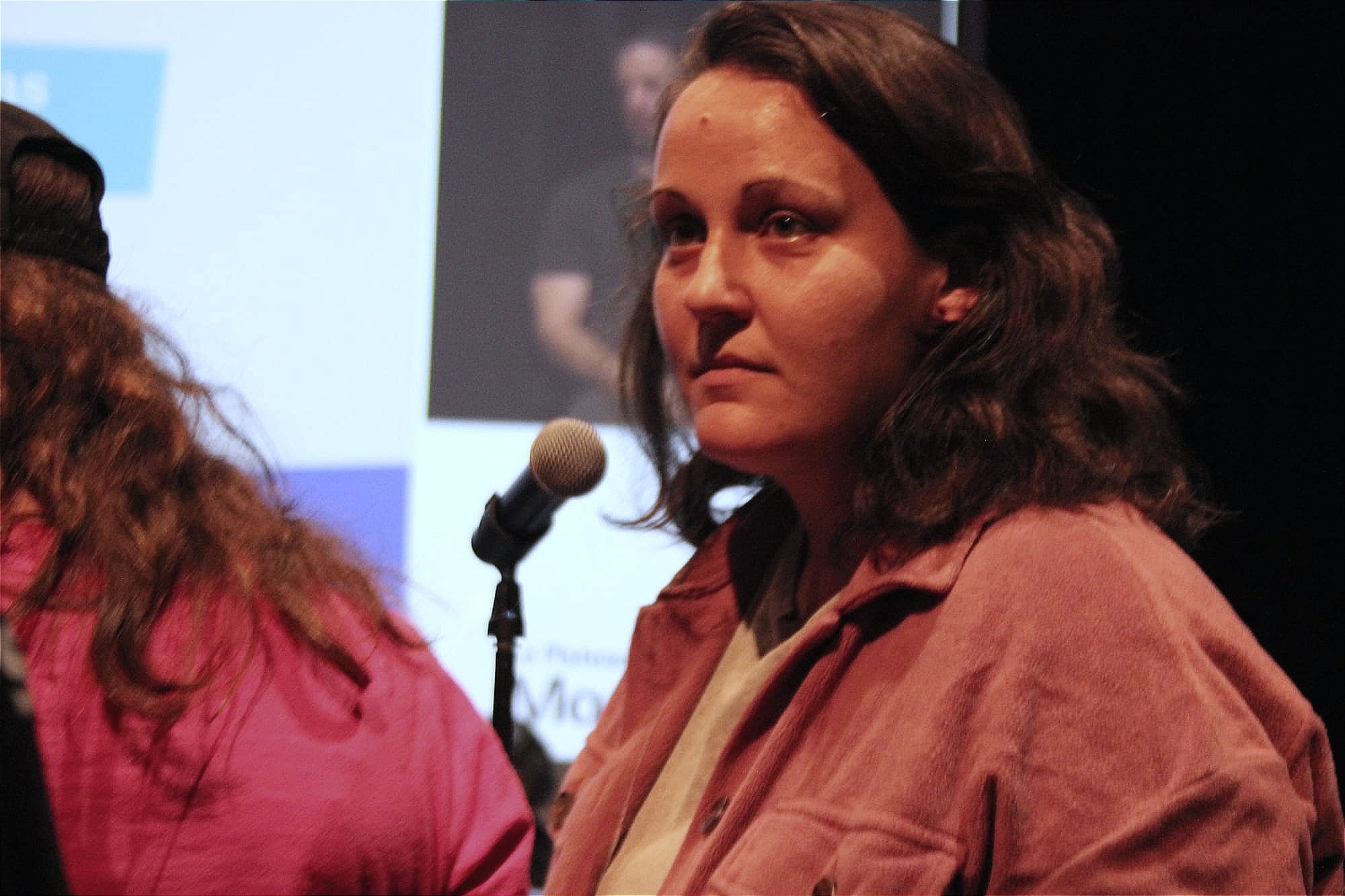 Mme Grenier lance un regard vers le public, alors qu'elle quitte le micro pour retourner s'asseoir. 