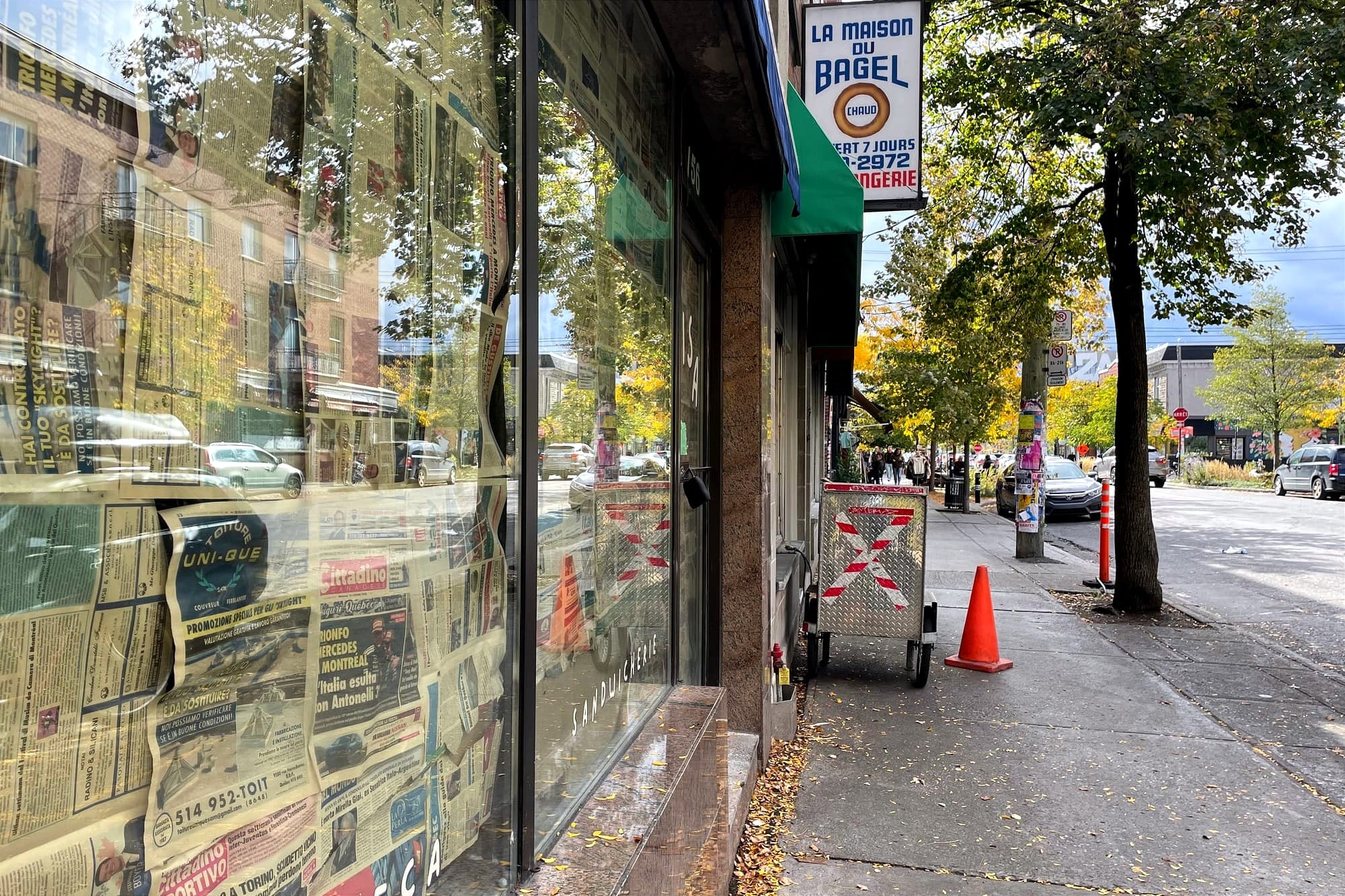 La vitrine d'un local commercial, situé à côté de La maison du bagel, est recouverte des papiers journaux.