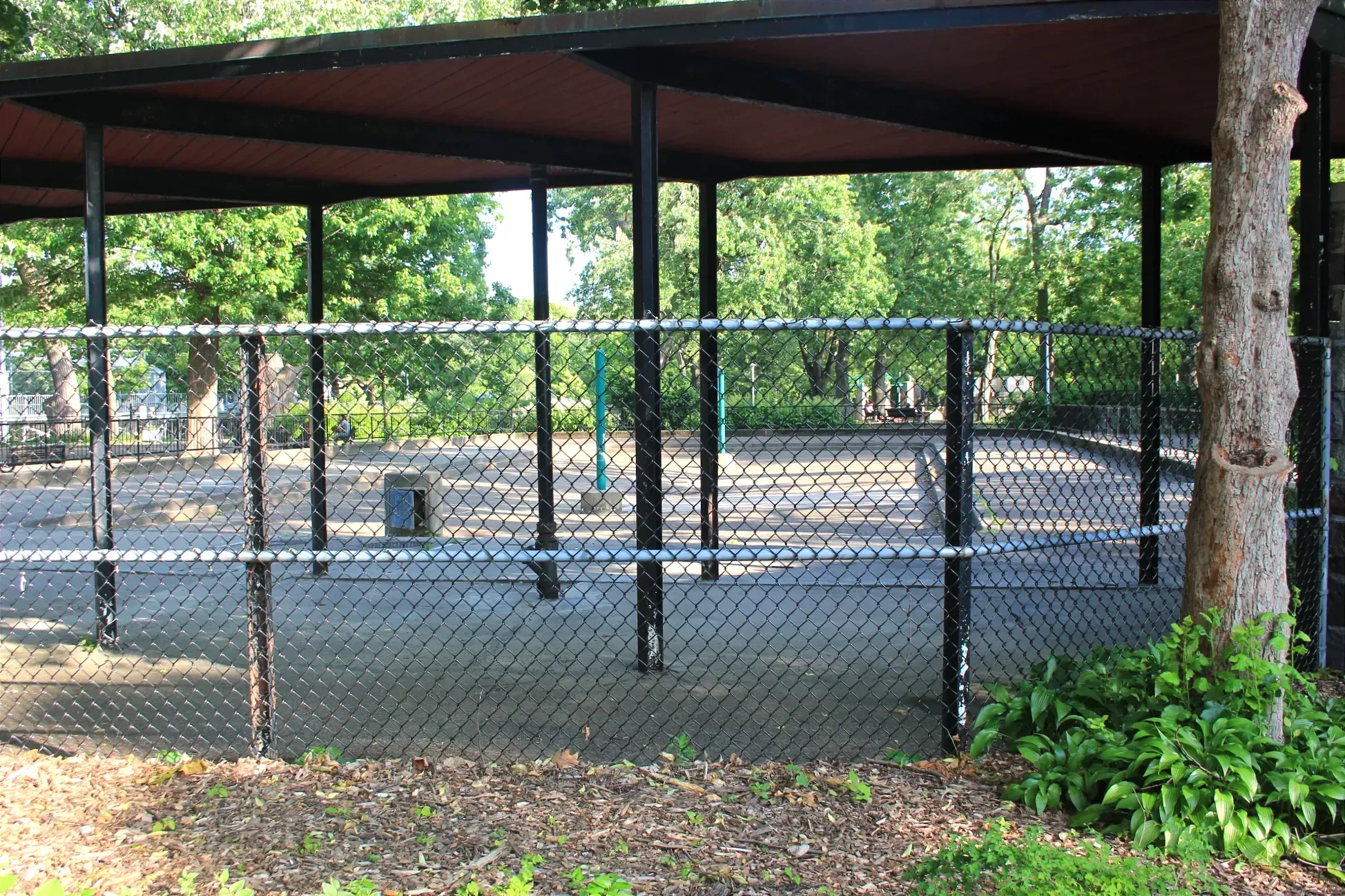 Vue d'une des pataugeoires du parc La Fontaine de l'extérieur de la clôture.