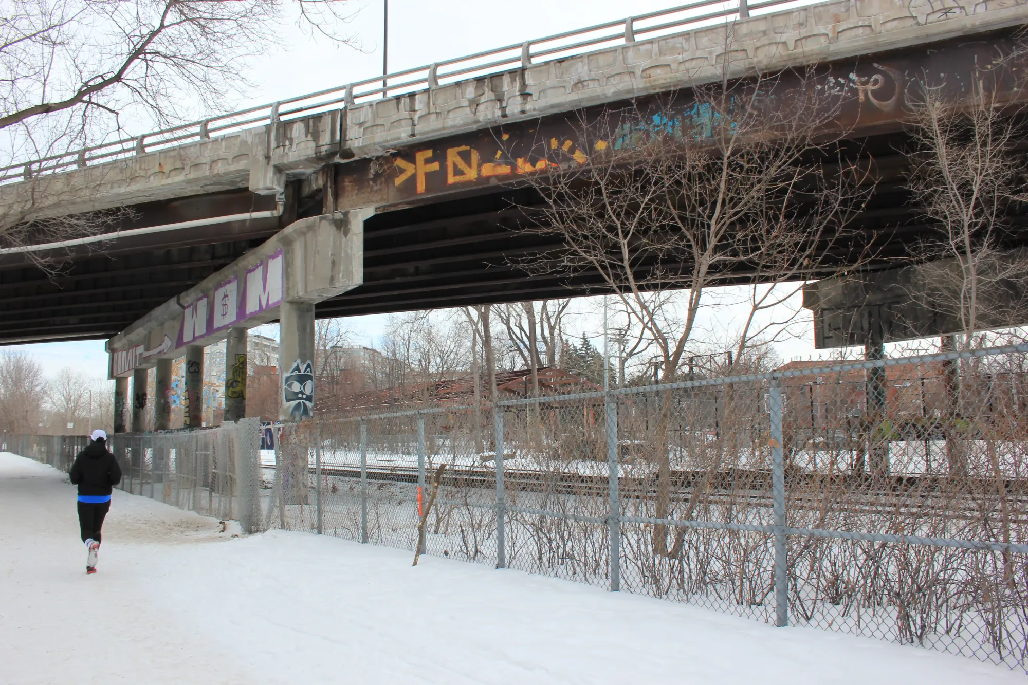 Une photo prise en hiver à partir du côté Rosemont, montrant le dessous du viaduc, avec une personne qui fait du jogging.