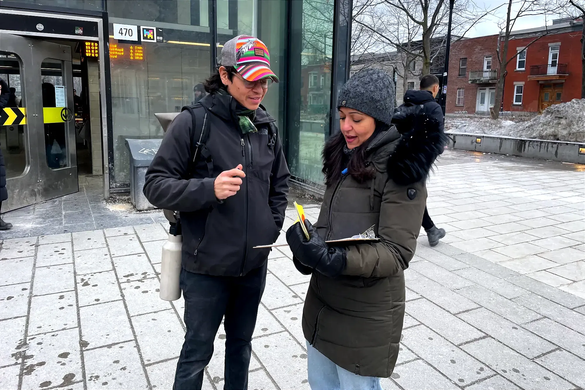 Mme Ghazal en discussion avec un citoyen, tracts à la main.