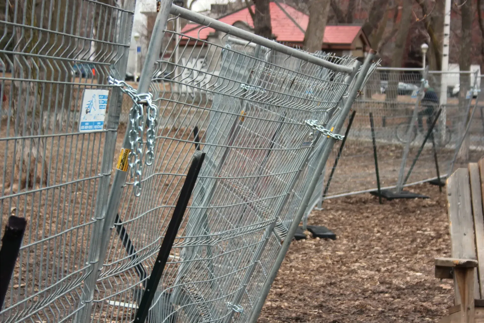 Les différents panneaux de la clôture sont liés par des chaînes. L'équilibre de certains éléments semble précaire.