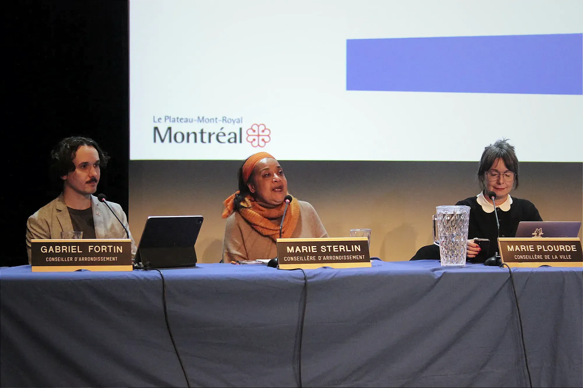 Mme Sterlin prend la parole à la table des élus, entourée de Gabriel Fortin et Marie Plourde.