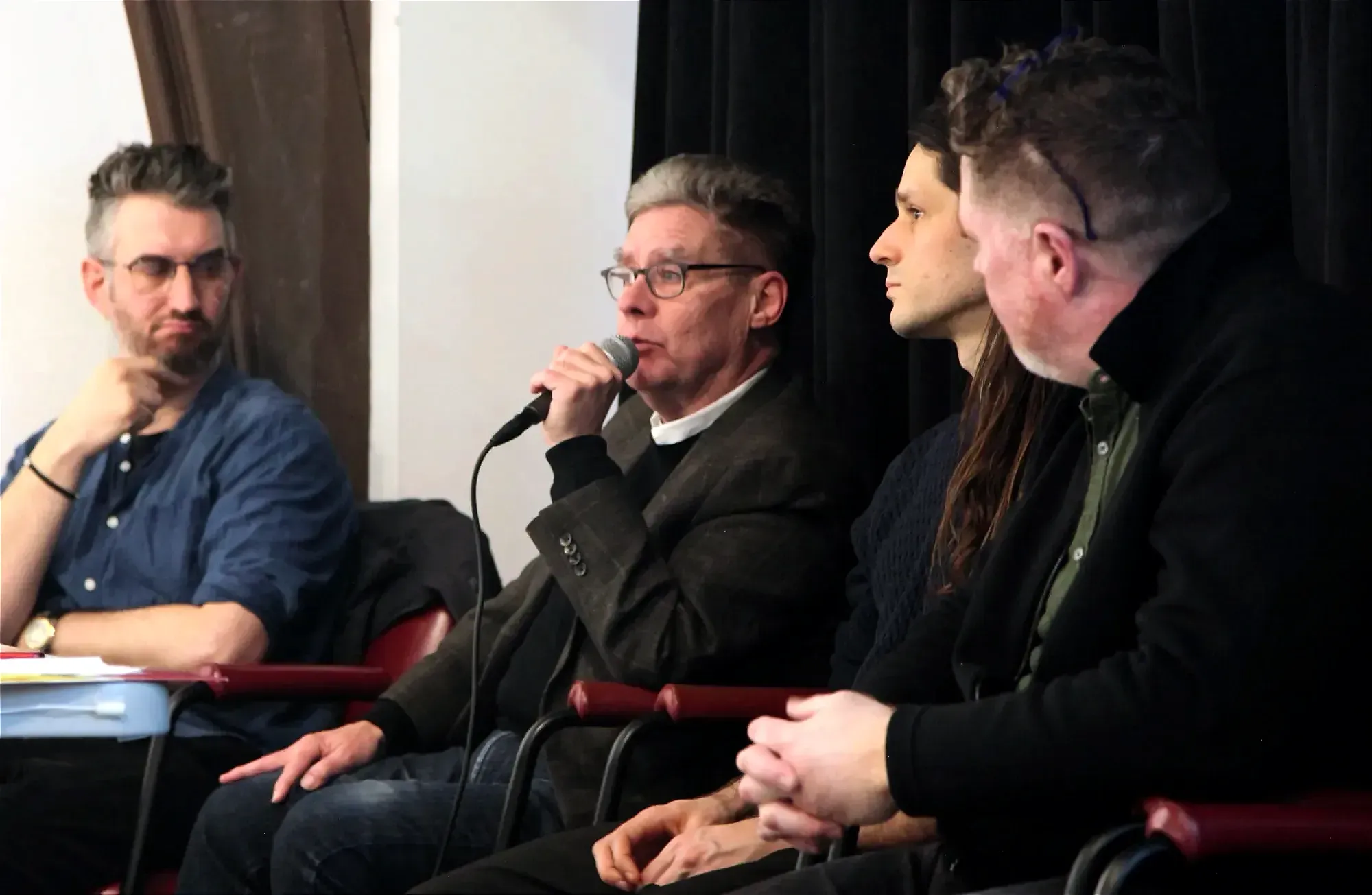 Les quatre panélistes sont assis côte à côte.