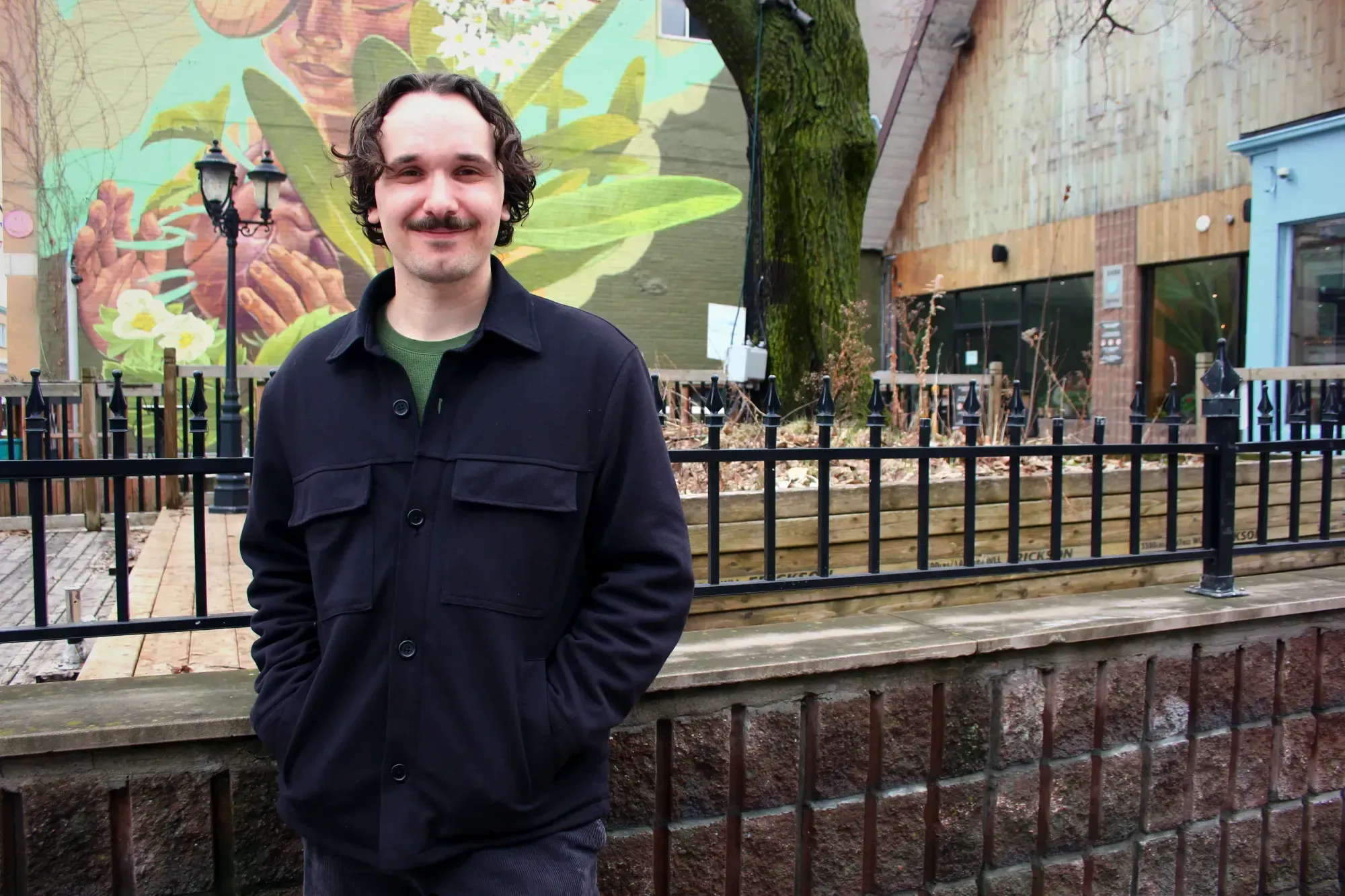 Gabriel Fortin pose devant la terrasse d'un restaurant situé au coin de la rue Milton et de l'avenue du Parc.