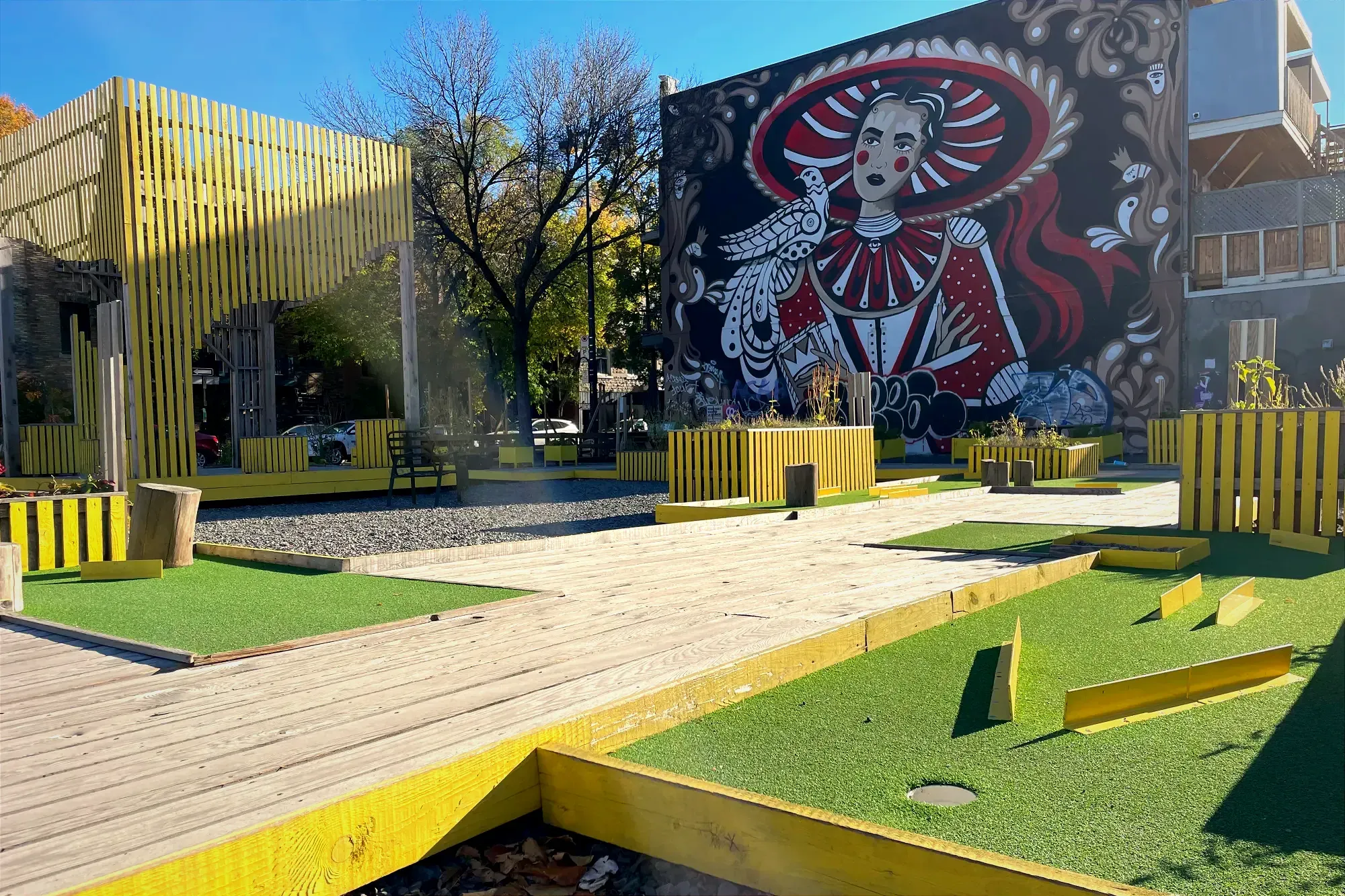 Une murale de type mexicain est visible en fond de cadre alors qu'un parcours de minigolf est visible à proximité de la caméra.
