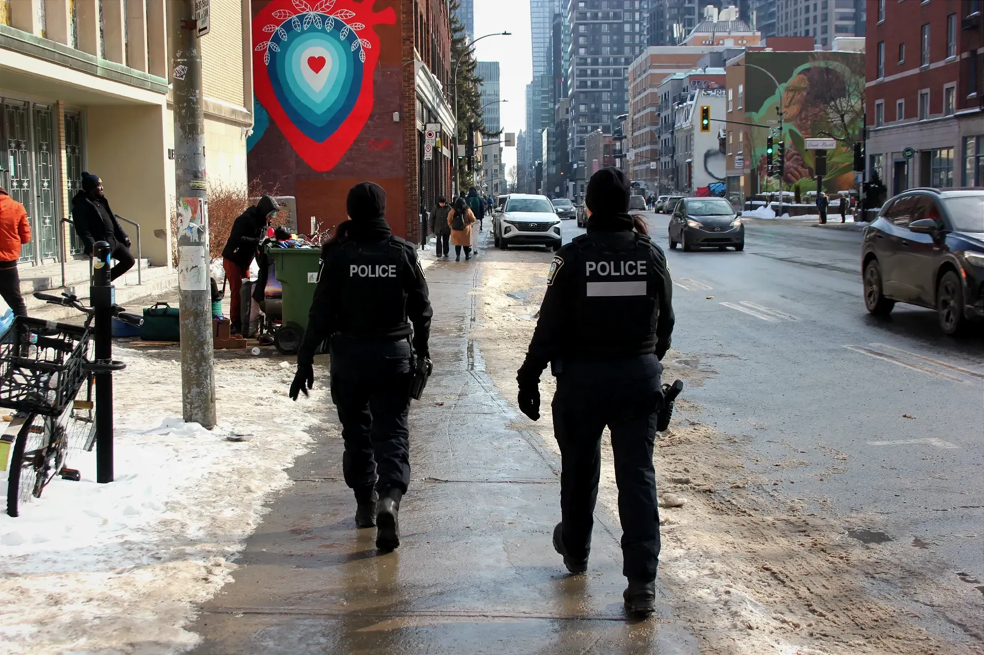 Les deux agentes sont des dos, face à la murale située à côté de l'église Notre-Dame-de-la-Salette.