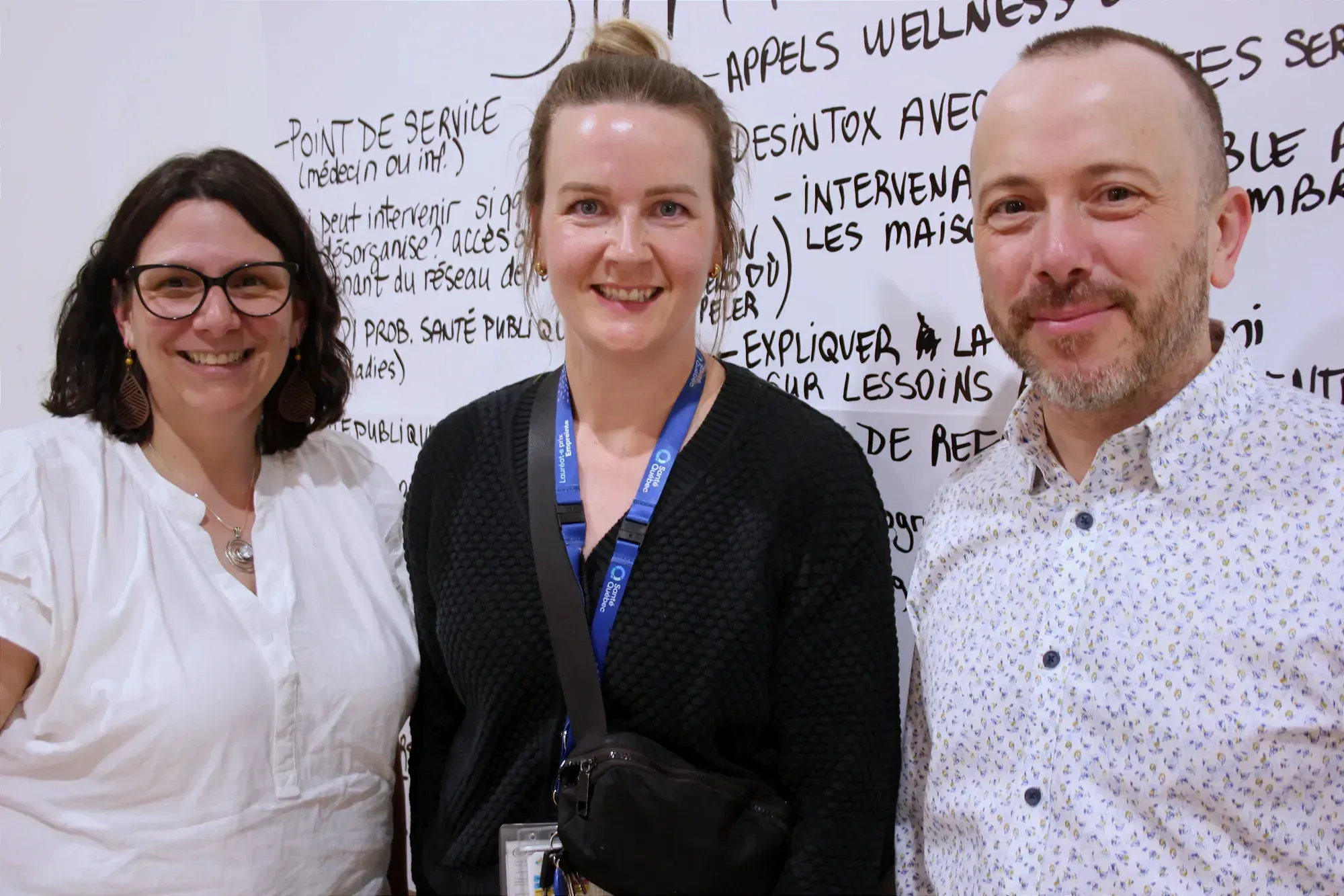 Les trois représentant de l'établissement de santé posent devant des cartons sur lesquels des notes de discussion ont été inscrites.
