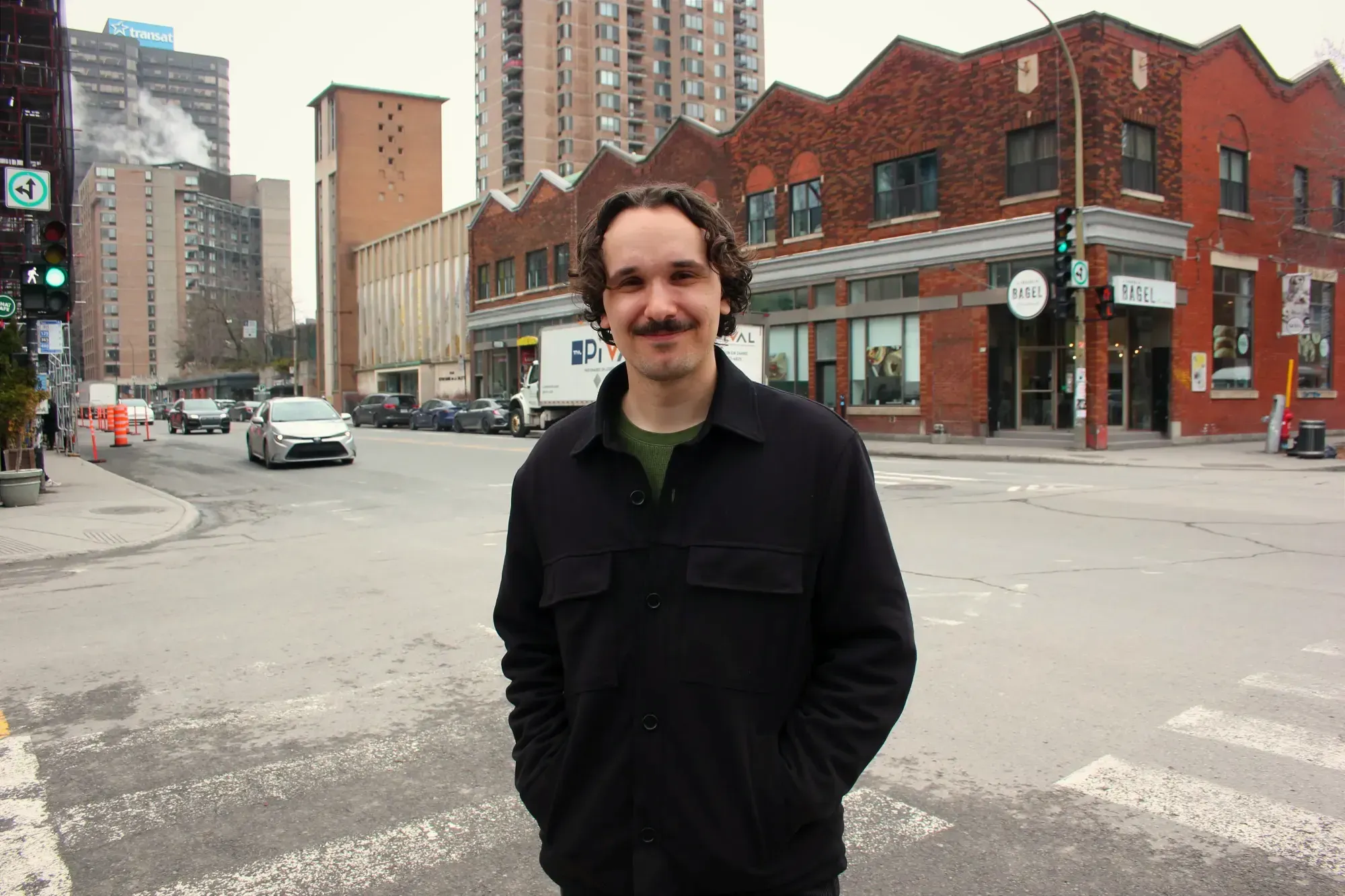 M. Fortin pose du côté sud-ouest de l'intersection, encore teintée d'un gris hivernal. On peut voir la façade est du tronçon de l'avenue du Parc, entre Milton et Prince-Arthur derrière lui.
