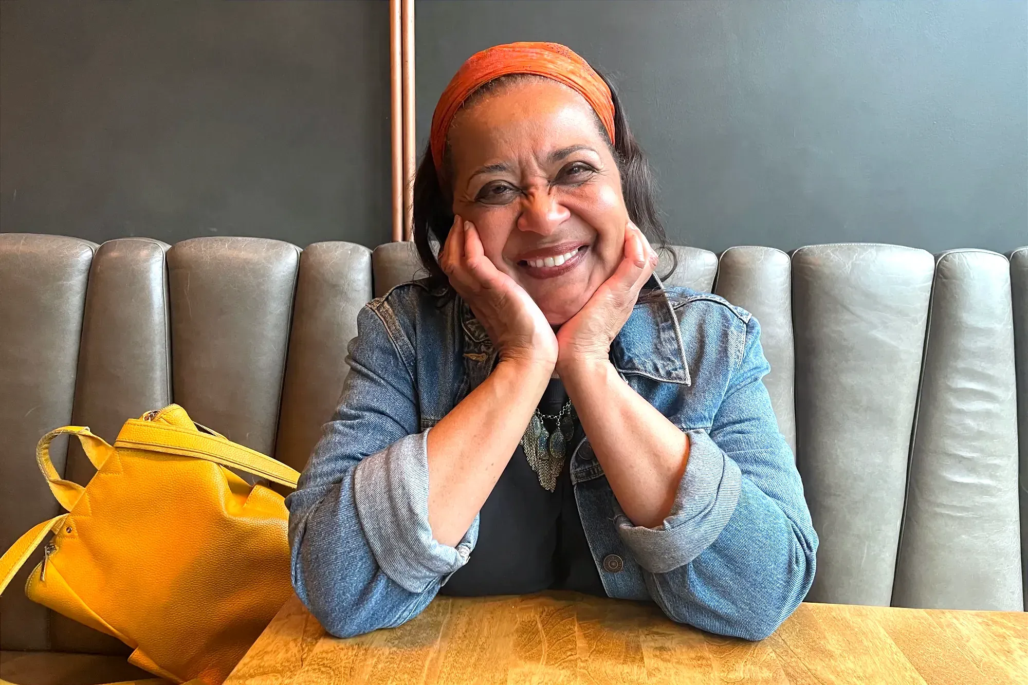 Mme Sterlin pose souriante, assise à une table de la microbrasserie Dieu du Ciel. 
