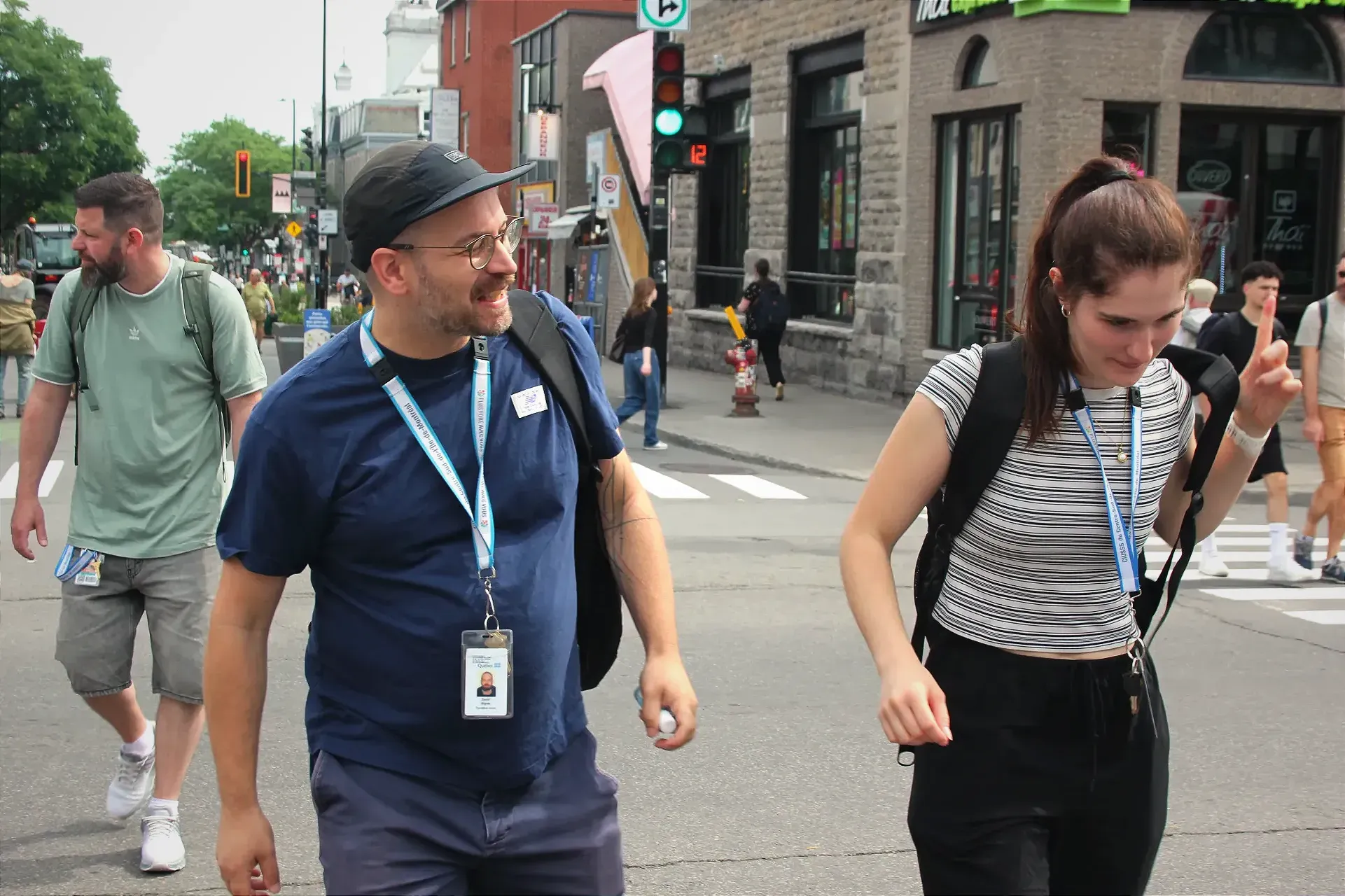 Replaçant son sac à dos sur son épaule, Raphaëlle Jouannaut traverse l'intersection St-Denis/Mont-Royal aux côtés de David Bigras. Gaël Bon Djemah suit derrière.