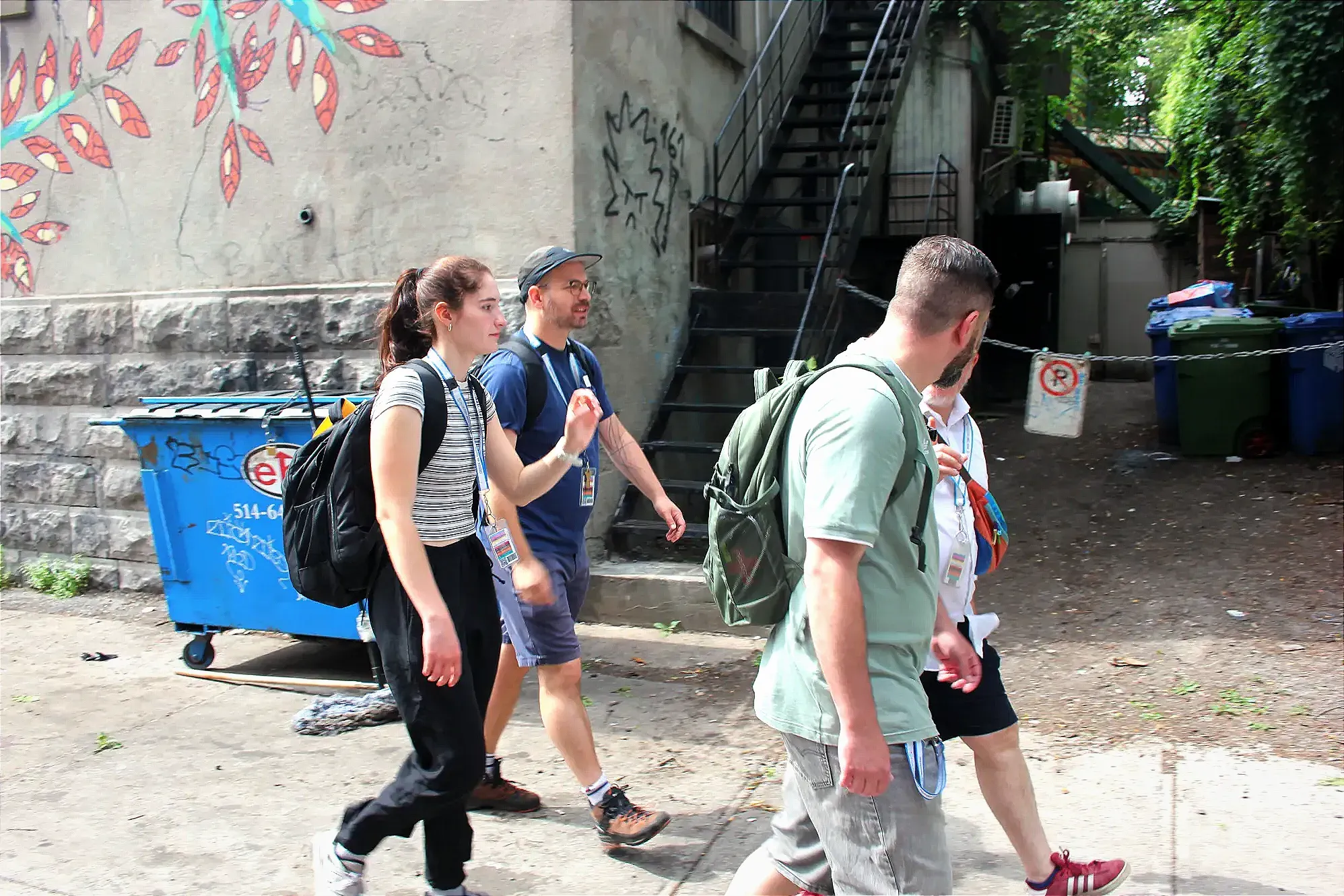 L'équipe marche sur le trottoir, croisant les bacs de matières résiduelles derrières un commerce de l'avenue du Mont-Royal.